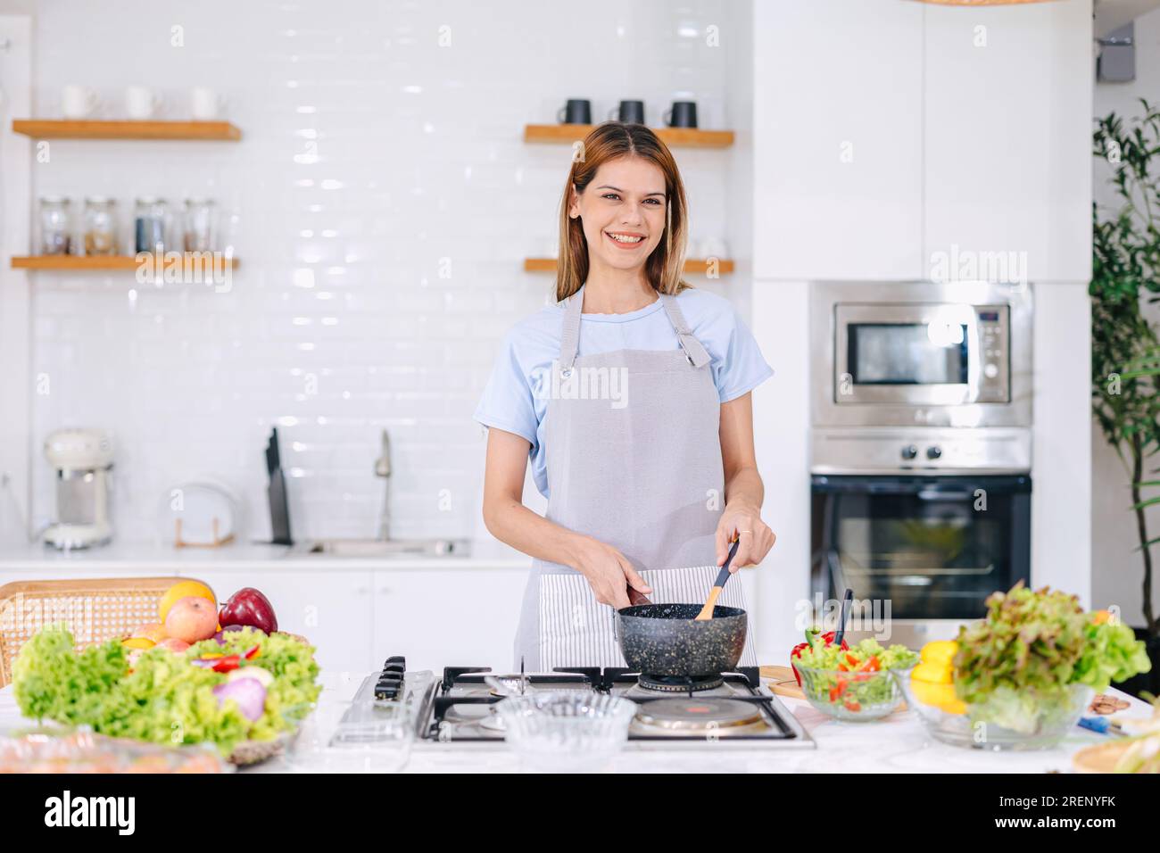 retrato mujer feliz disfruta sonriendo cocinando sopa caliente de alimentos en la cocina casera aprendiendo verduras saludables cocinan Foto de stock