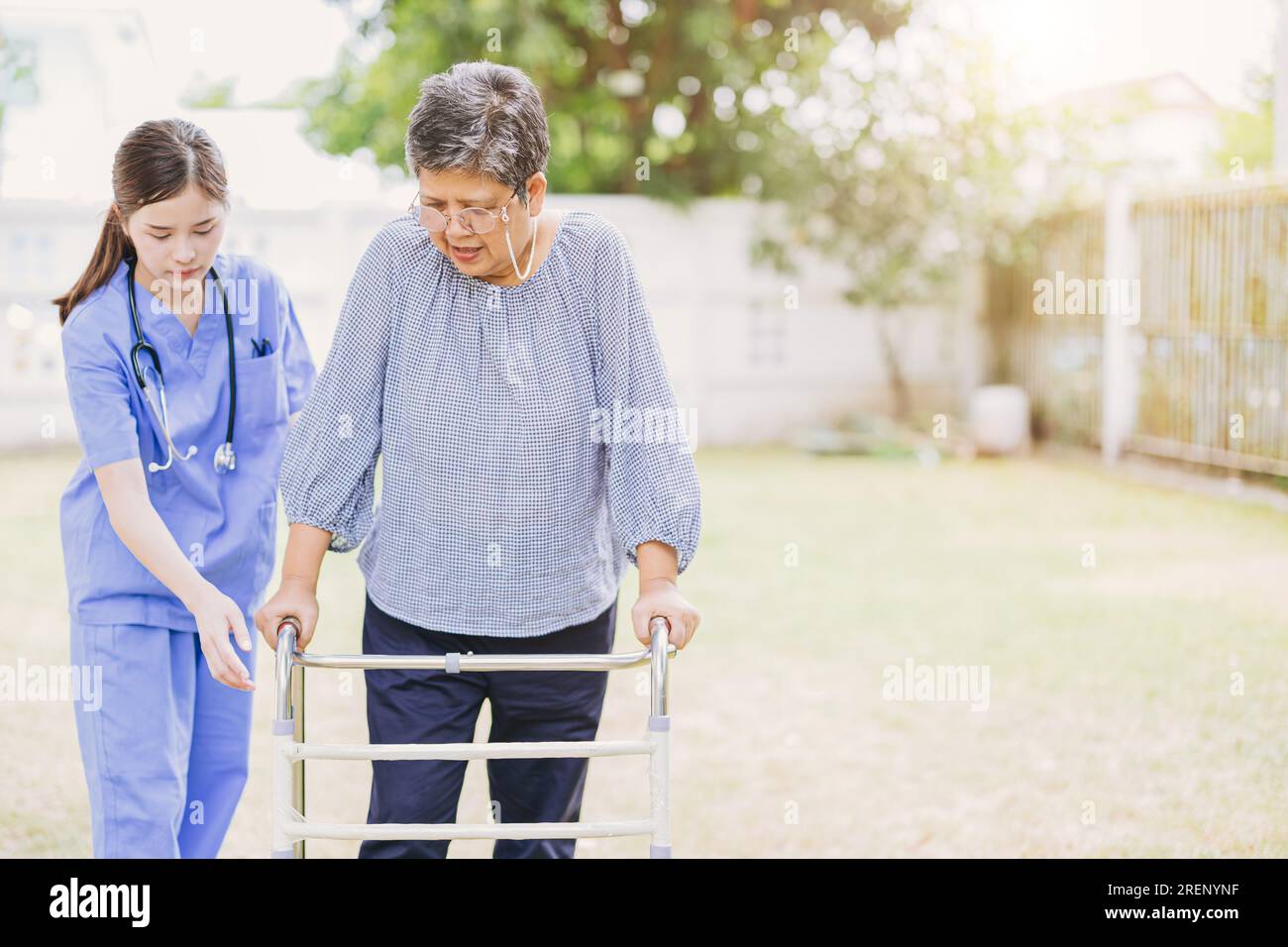 la mujer adulta mayor con discapacidad que usa la práctica de caminar en el hogar enfermera médico o fisioterapeuta ayuda a relajarse al aire libre Foto de stock