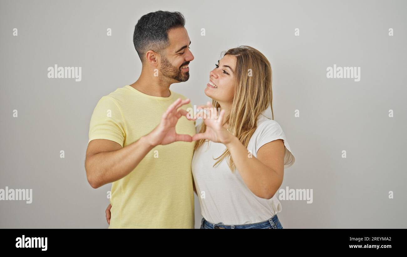 Hombre Y Mujer Pareja Abrazándose Uno Al Otro Haciendo Gesto De Corazón Sobre Fondo Blanco