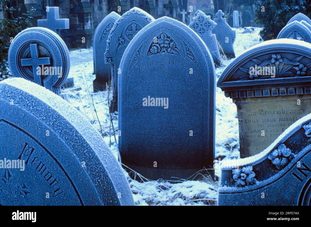 Imagen de archivo, tomada a principios de 1980, de lápidas o tumbas en un patio de la iglesia, en un día nevado en invierno, en Manchester, Inglaterra, Reino Unido, tungsteno película luz del día azul fundido, Foto de stock