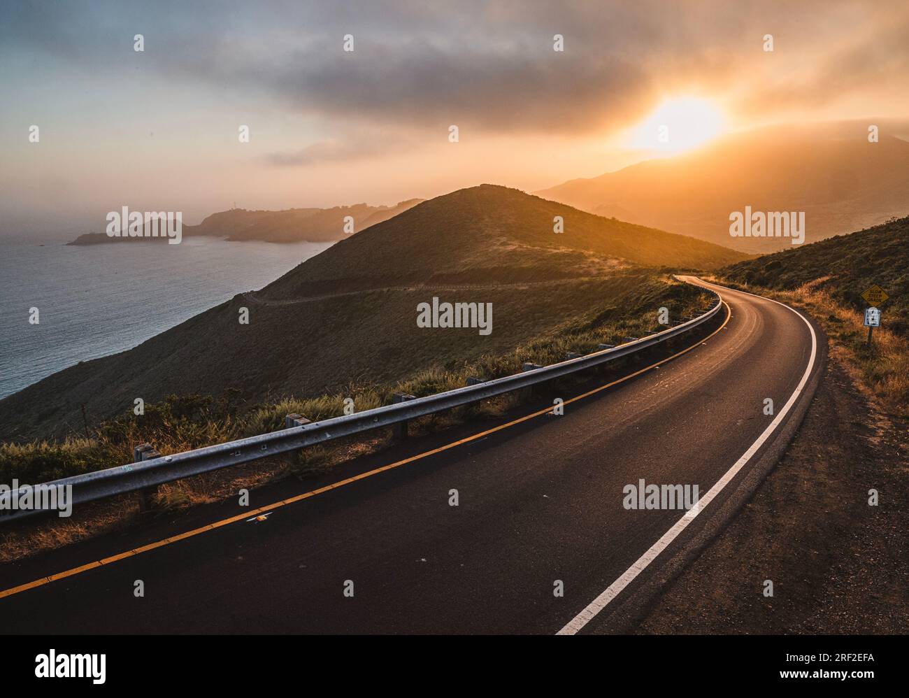 El sol se pone sobre la carretera de montaña, Monumento Nacional Marin Headlands Foto de stock