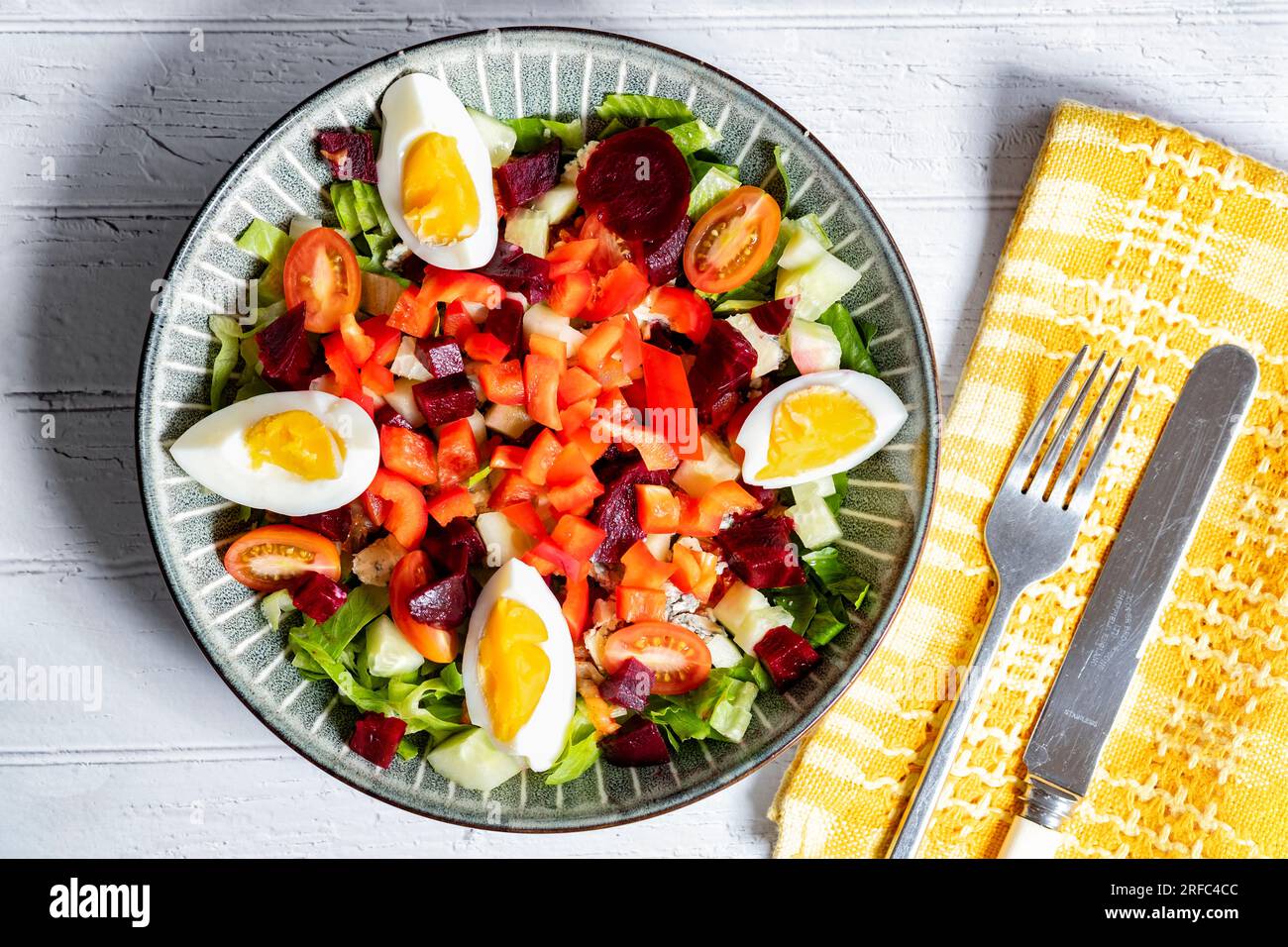 Una saludable ensalada de dieta mediterránea servida en un tazón que contiene ingredientes de ensalada de colores como remolacha de pimientos de tomate, huevos y lechuga. Foto de stock