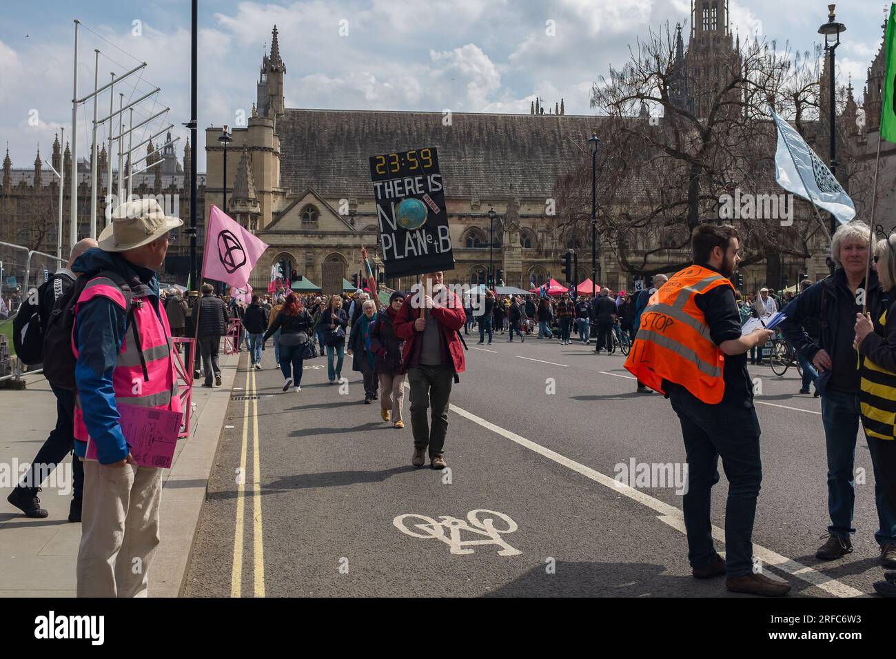 Londres, Reino Unido, 2023. En el Día de la Tierra, un activista por el clima sostiene un cartel que dice: No hay planeta B, con Westminster en el fondo Foto de stock