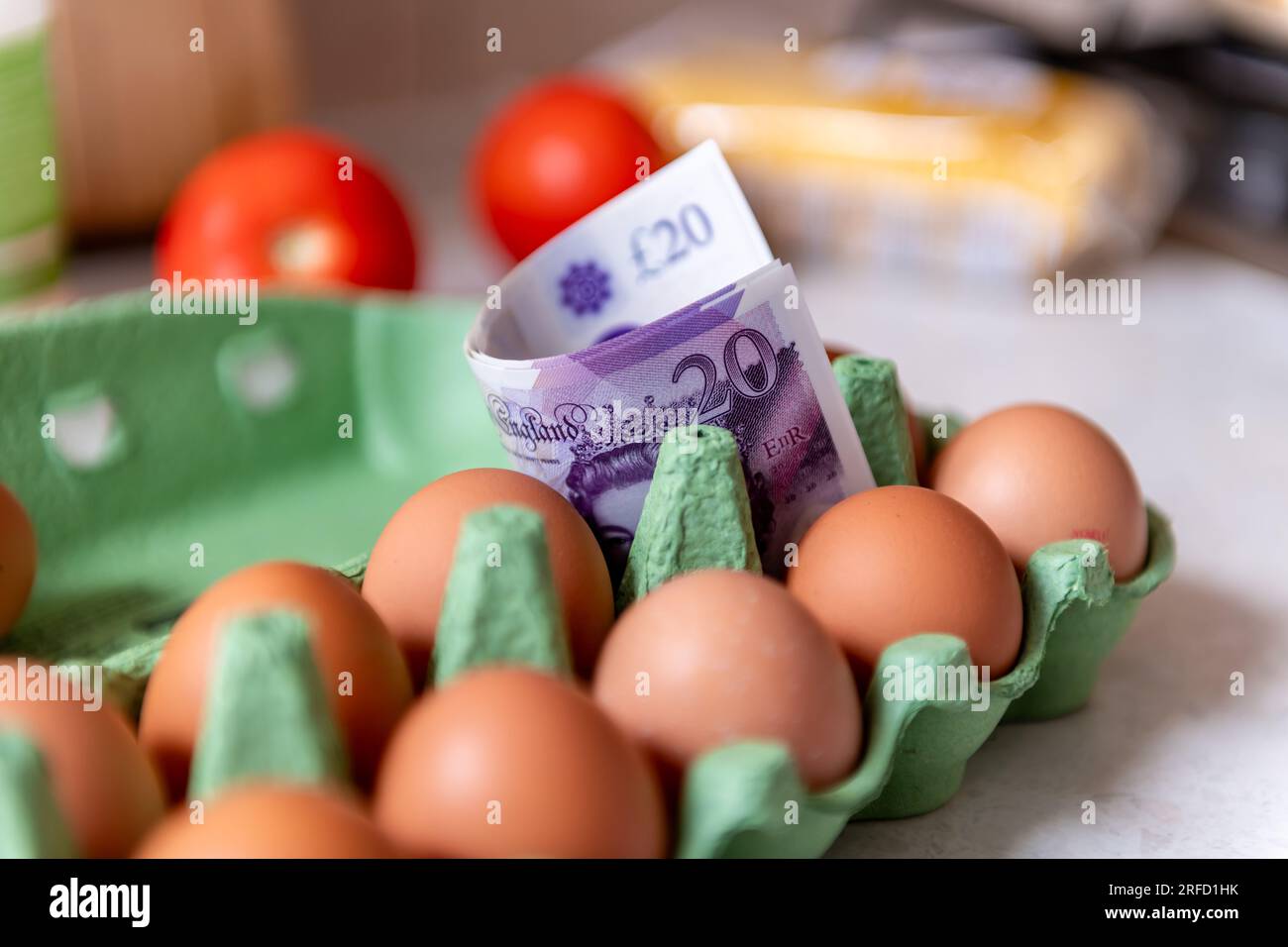 Un concepto de costo de vida, inflación de alimentos con billetes de banco de libra esterlina en un paquete de huevos. Foto de stock