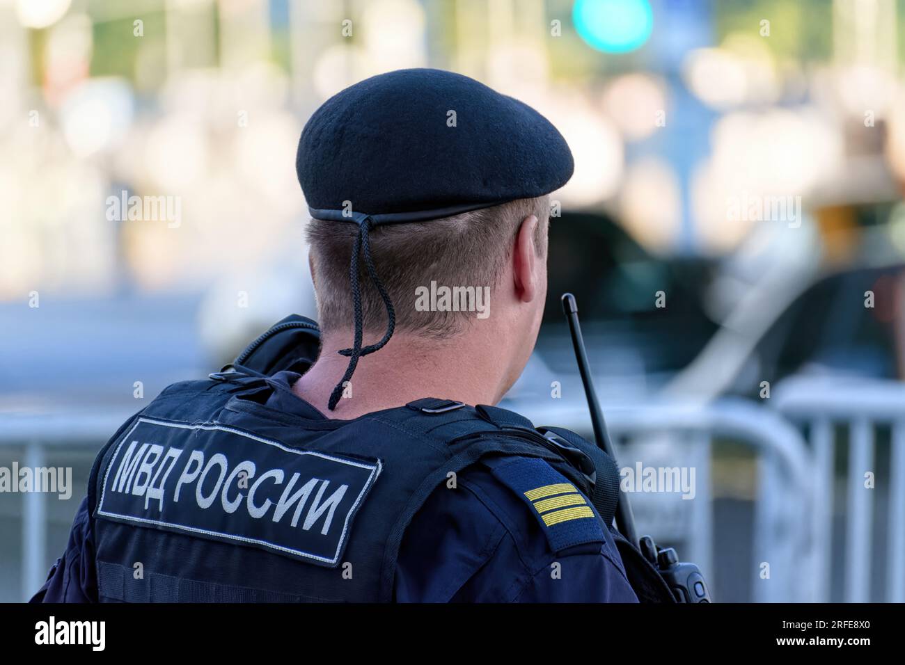 Oficial de policía ruso de la Guardia Nacional en chaleco antibalas patrulla la calle de la ciudad. Traducción de la inscripción en el dorso masculino: 'Ministerio de Interna Foto de stock