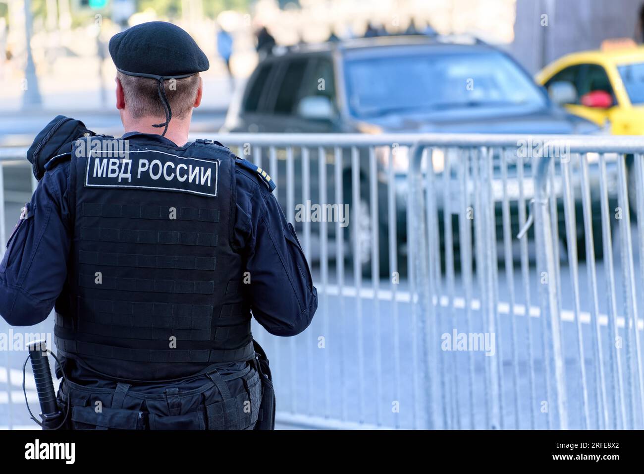 Oficial de policía ruso de la Guardia Nacional en chaleco antibalas patrulla la calle de la ciudad. Traducción de la inscripción en el dorso masculino: 'Ministerio de Interna Foto de stock