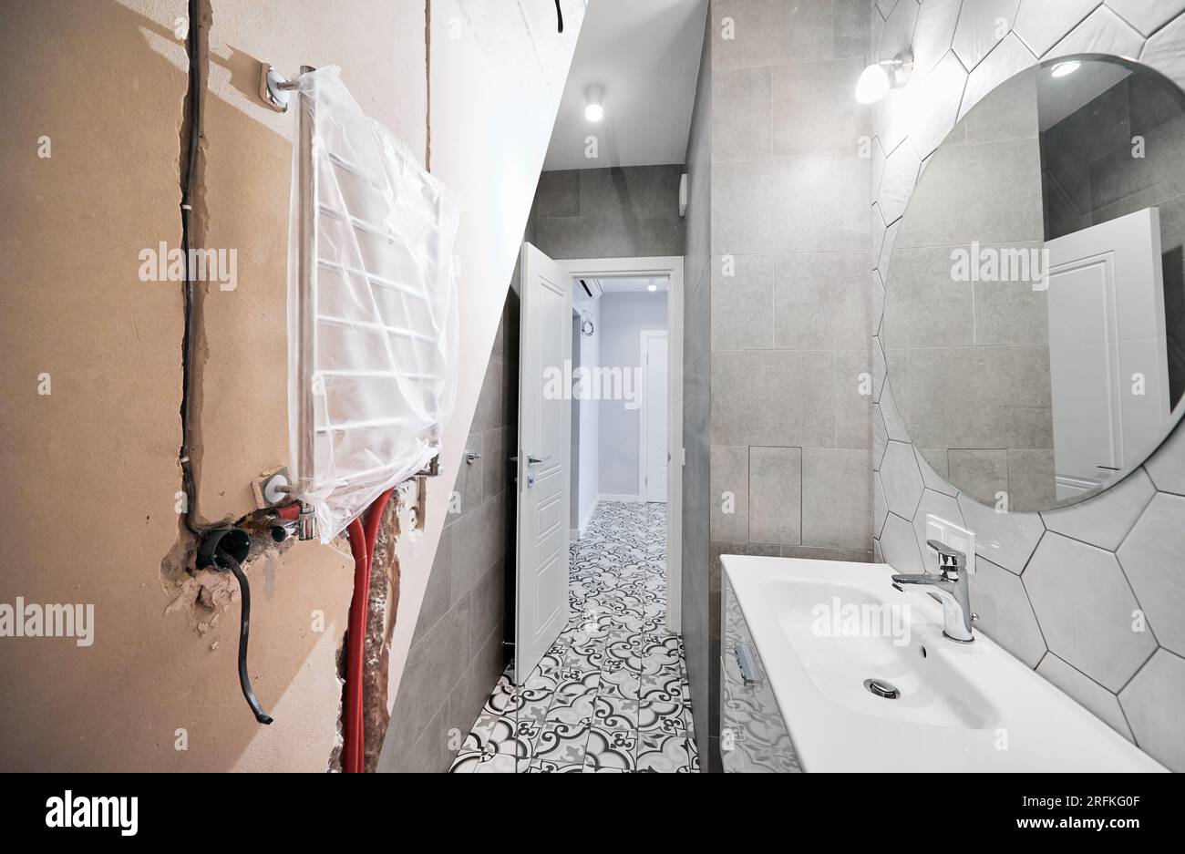Cuarto de baño del apartamento con secador de toallas eléctrico antes y  después de la restauración. Piso antiguo y nuevo baño reformado con lavabo  y espejo Fotografía de stock - Alamy