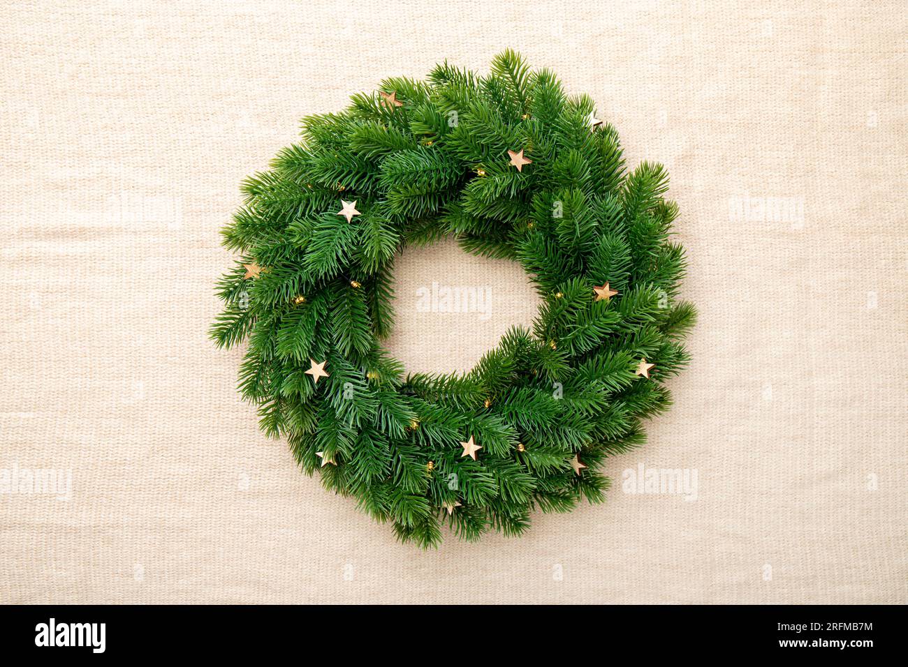 Fondo de guirnalda de Navidad mínimo verde vacío en tela textil marrón. Foto de stock