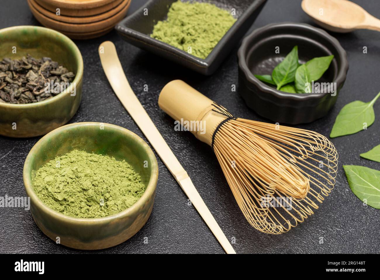 Batidor de bambú para hacer té Matcha. Polvo de té matcha verde en un  tazón. Hojas verdes. Fondo negro Fotografía de stock - Alamy