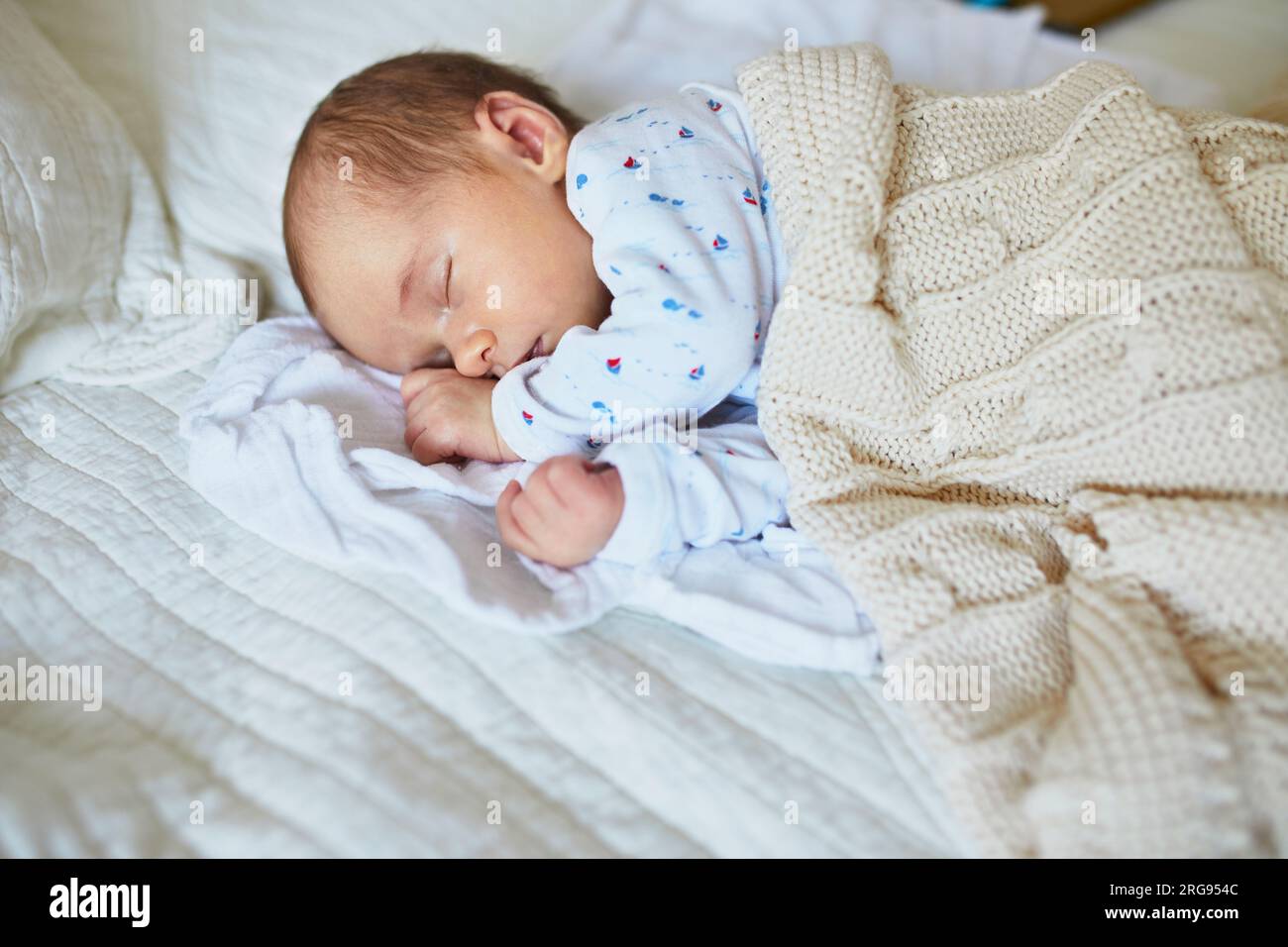 Bebé recién nacido niño en cama. Niño recién nacido duerme bajo una manta  tejida de color azul. Los niños duermen. Ropa de cama para niños Fotografía  de stock - Alamy