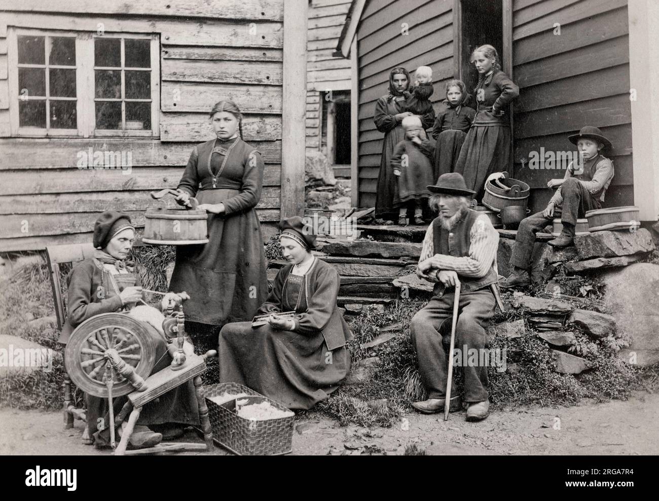 Vintage siglo 19th Fotografía: Noruega, familia rural fuera de su casa con rueda giratoria Foto de stock