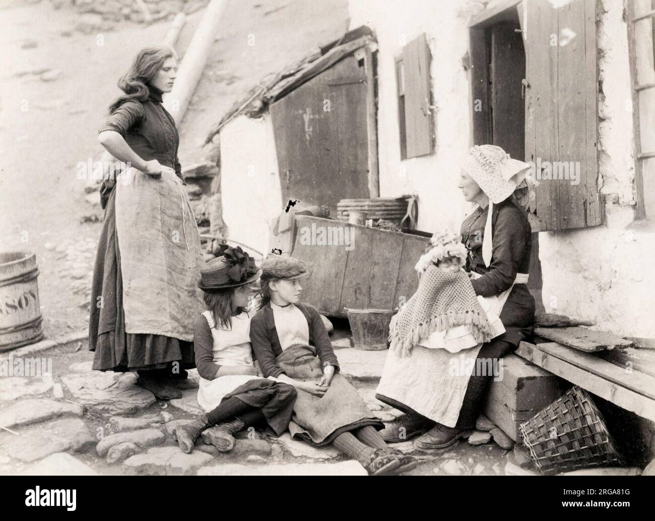 Familia pesquera fuera de su casa de campo, Staithes, Yorkshire. Fotografía vintage del siglo 19th. Foto de stock