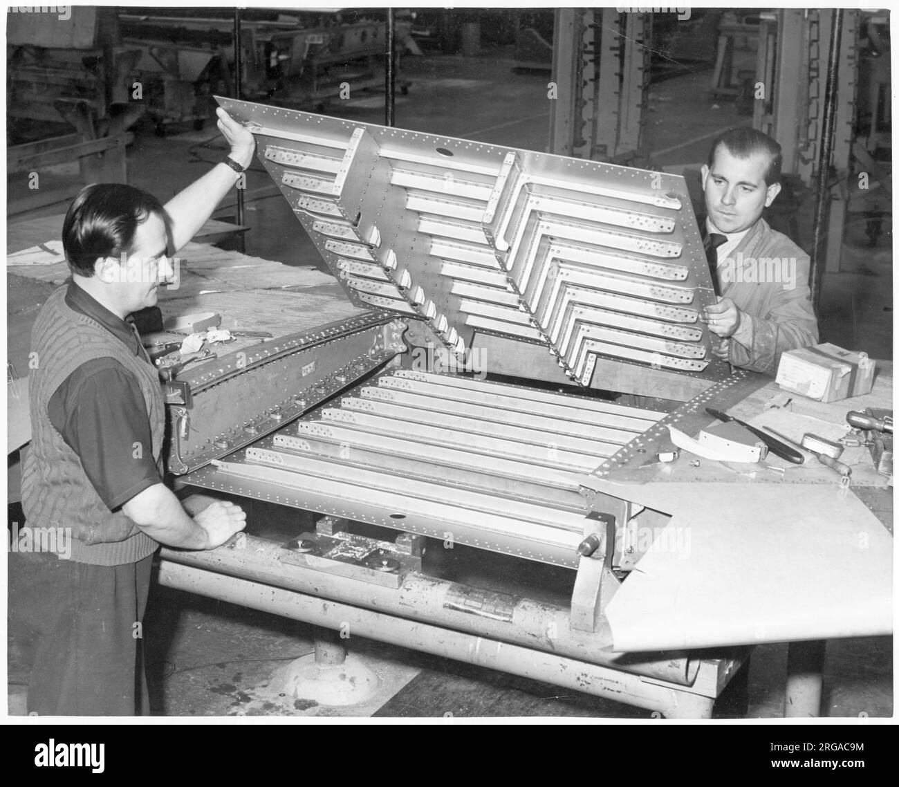 Folland fo.139 Gnat. Dos inspectores de la estructura de una sección central del ala Gnat antes del montaje, en la fábrica de Folland Eastliegh, cerca de Southampton. Foto de stock