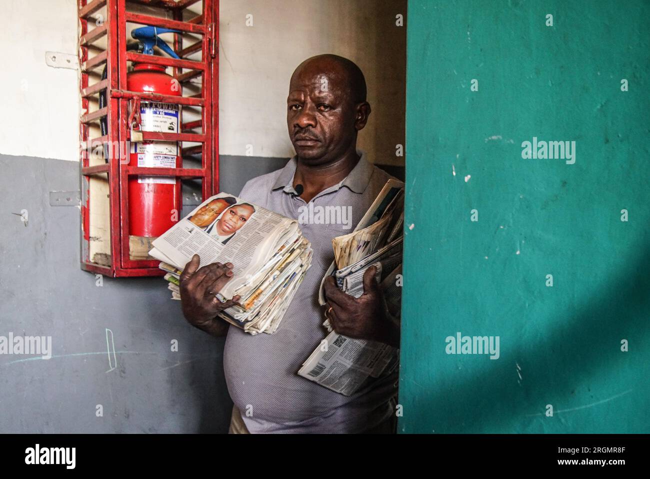 Josephat Mureithi de 54 años, hermano del periodista keniano asesinado, William Munuhe, lleva viejos periódicos kenianos que cubrían la historia del presunto prófugo del genocidio ruandés Felicien Kabuga en su taller de reparación de electrónica en la ciudad de Nakuru. La familia del difunto periodista keniano William Munuhe, quien fue asesinado el 14 de enero de 2003, mientras ayudaba a la policía y al FBI a localizar a Felicien Kabuga. Se espera que el presunto cerebro del genocidio ruandés enfermo, Felicien Kabuga, de 87 años de edad, sea liberado tras el Mecanismo Residual Internacional de las Naciones Unidas para la Crimina Foto de stock