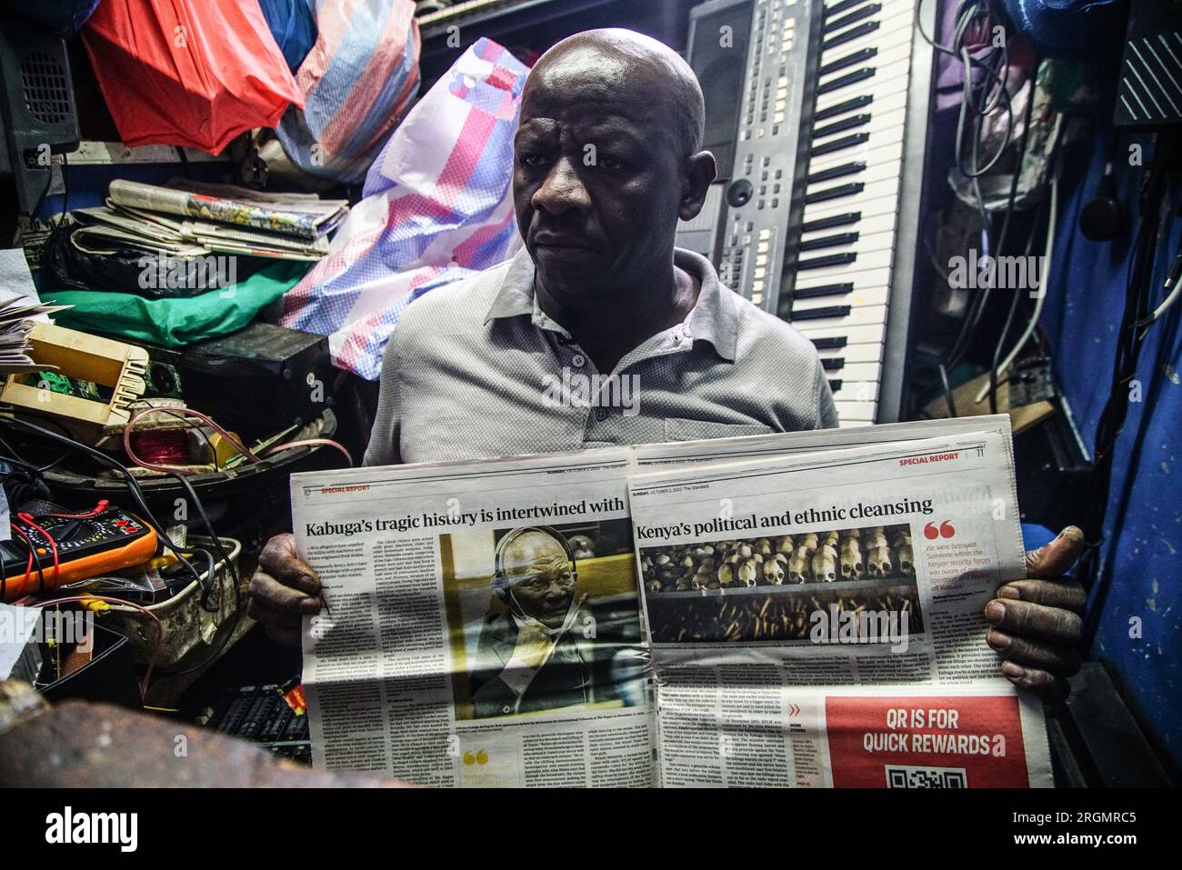 Josephat Mureithi de 54 años, hermano del periodista keniano asesinado, William Munuhe, muestra un viejo periódico keniano que cubría la historia del presunto prófugo del genocidio ruandés Felicien Kabuga en su taller de reparación de electrónica en la ciudad de Nakuru. La familia del difunto periodista keniano William Munuhe, quien fue asesinado el 14 de enero de 2003, mientras ayudaba a la policía y al FBI a localizar a Felicien Kabuga. Se espera que el presunto cerebro del genocidio ruandés enfermo, Felicien Kabuga, de 87 años de edad, sea liberado tras el Mecanismo Residual Internacional de Crim de las Naciones Unidas Foto de stock
