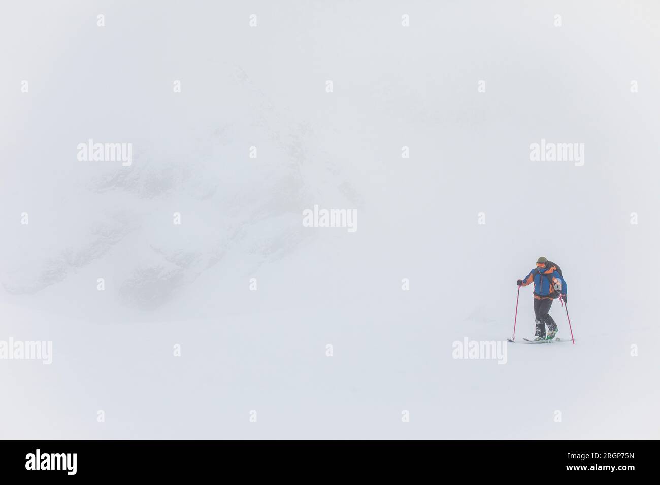 Hombre esquí de travesía en condiciones de blanco, mala visibilidad Foto de stock