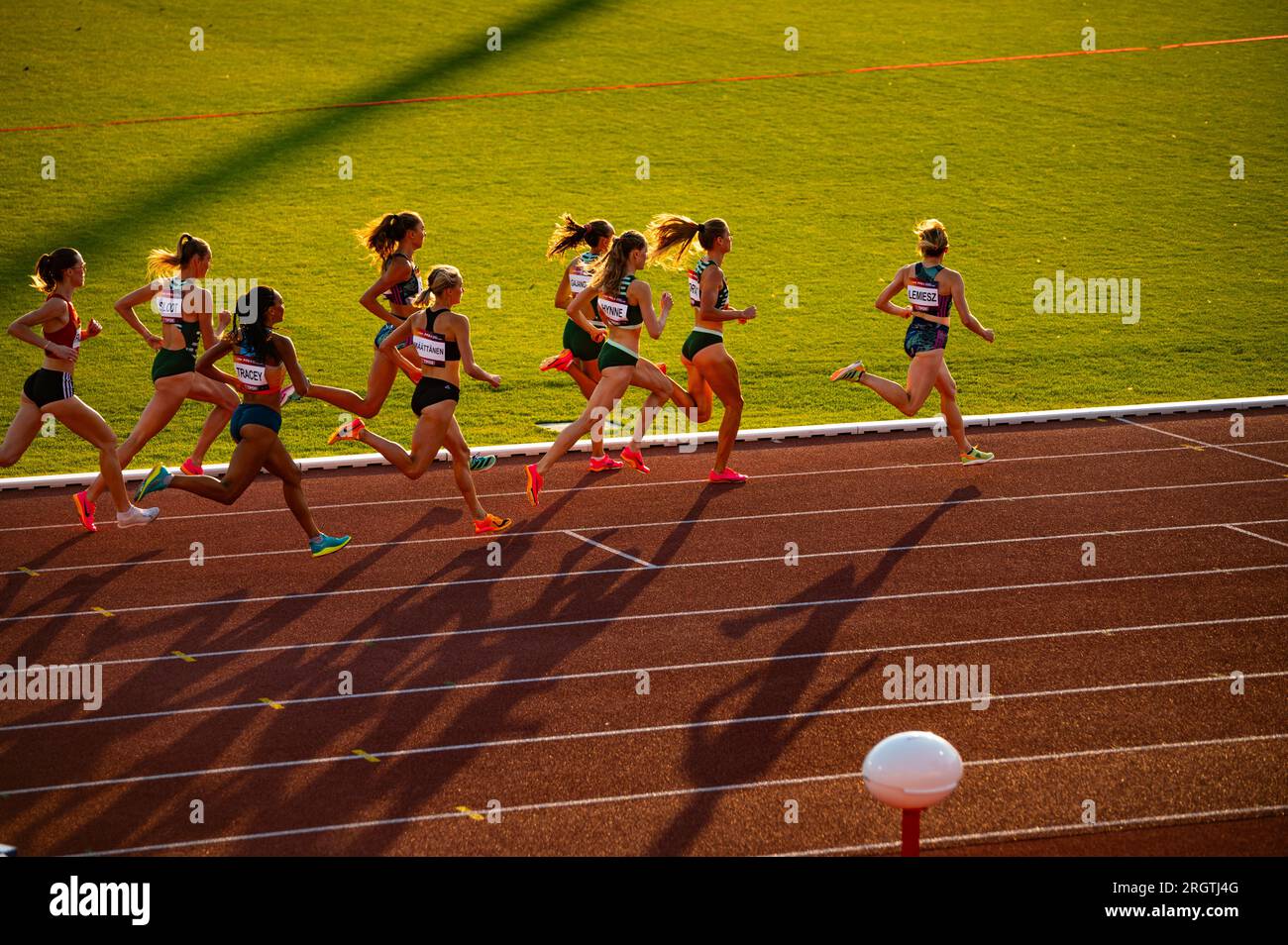 B. BYSTRICA, ESLOVAQUIA, 20 DE JULIO de 2023: Brillante Crepúsculo Acción: Las mujeres participan en 800m Carrera en medio de la hermosa iluminación del atardecer en la pista y el campo C. Foto de stock