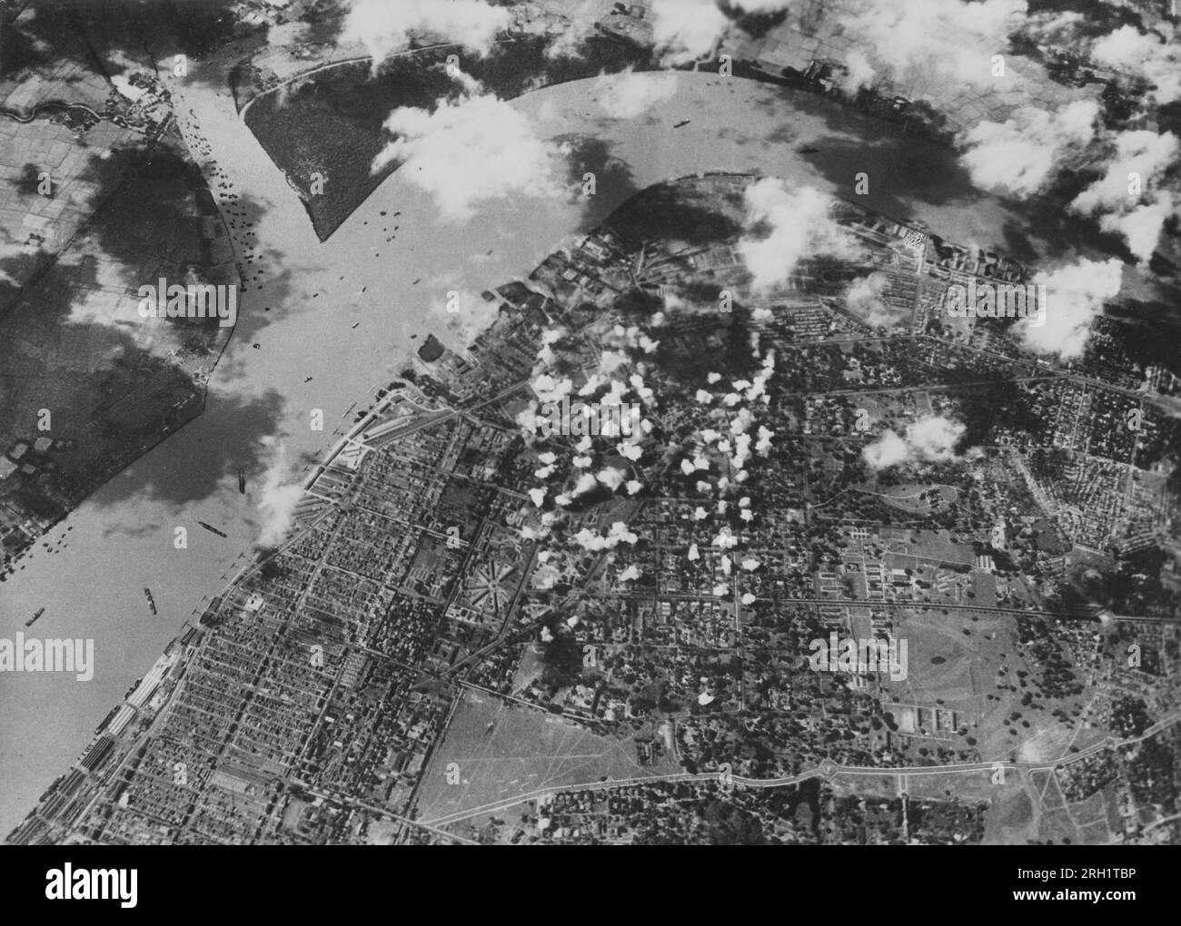 Campaña Birmania, 1941-1945. Una foto de reconocimiento aéreo muestra la capital de Birmania, Rangún, bajo intensos bombardeos durante un ataque aéreo del Servicio Aéreo del Ejército Imperial Japonés. Los ataques aéreos japoneses se llevaron a cabo en Rangún desde diciembre de 1941 hasta la caída de la ciudad a manos de las fuerzas japonesas en marzo de 1942. Foto de stock