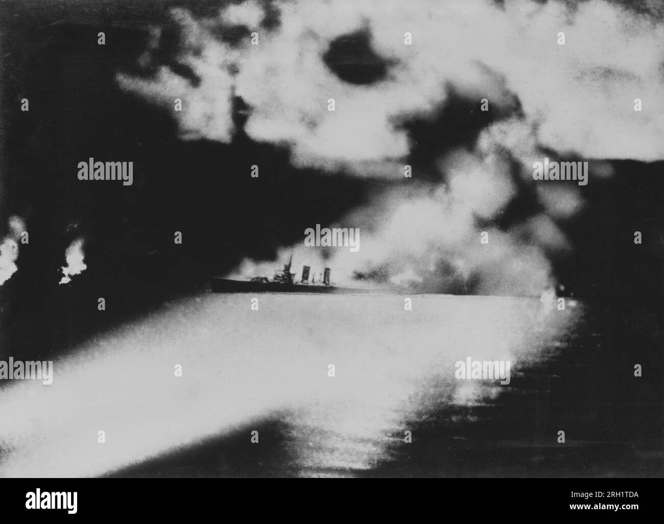 Batalla de la isla de Savo, agosto de 8-9 1942. El crucero USS Quincy, capturado bajo la mirada de los reflectores japoneses, se ve incendiado después de sostener el fuego naval y de torpedos frente a la costa de la isla de Savo, el 9 1942 de agosto. USS Quincy se hundiría de estos daños poco después. Foto de stock