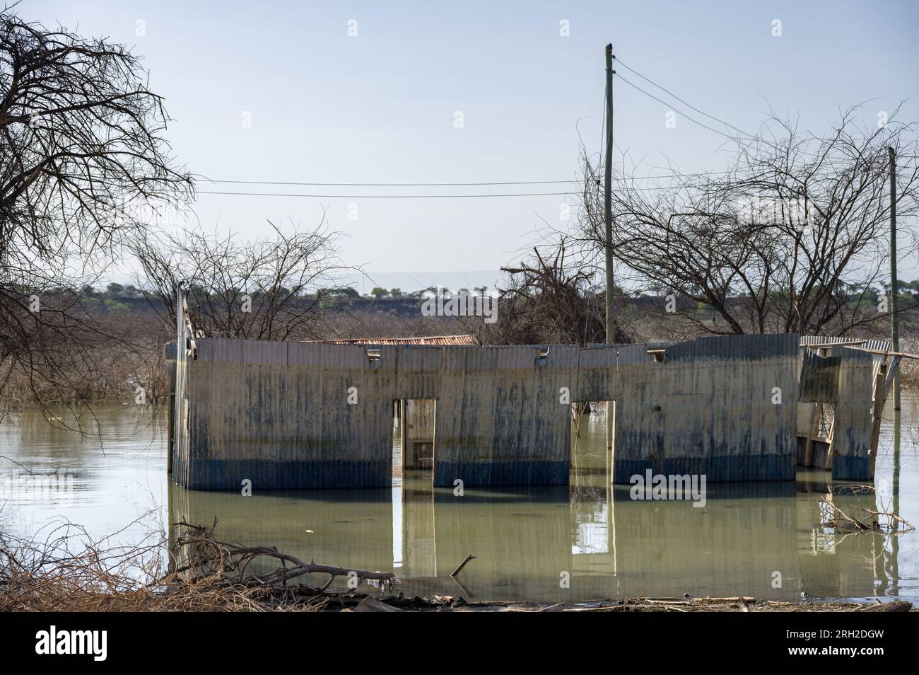 Un edificio abandonado de metal corrugado está parcialmente inundado en el agua, en el condado de Baringo, Kenia Foto de stock