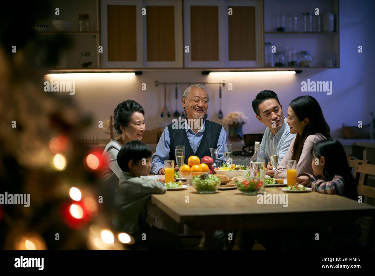 familia asiática de tres generaciones gatthering en casa teniendo la cena celebrando la navidad Foto de stock