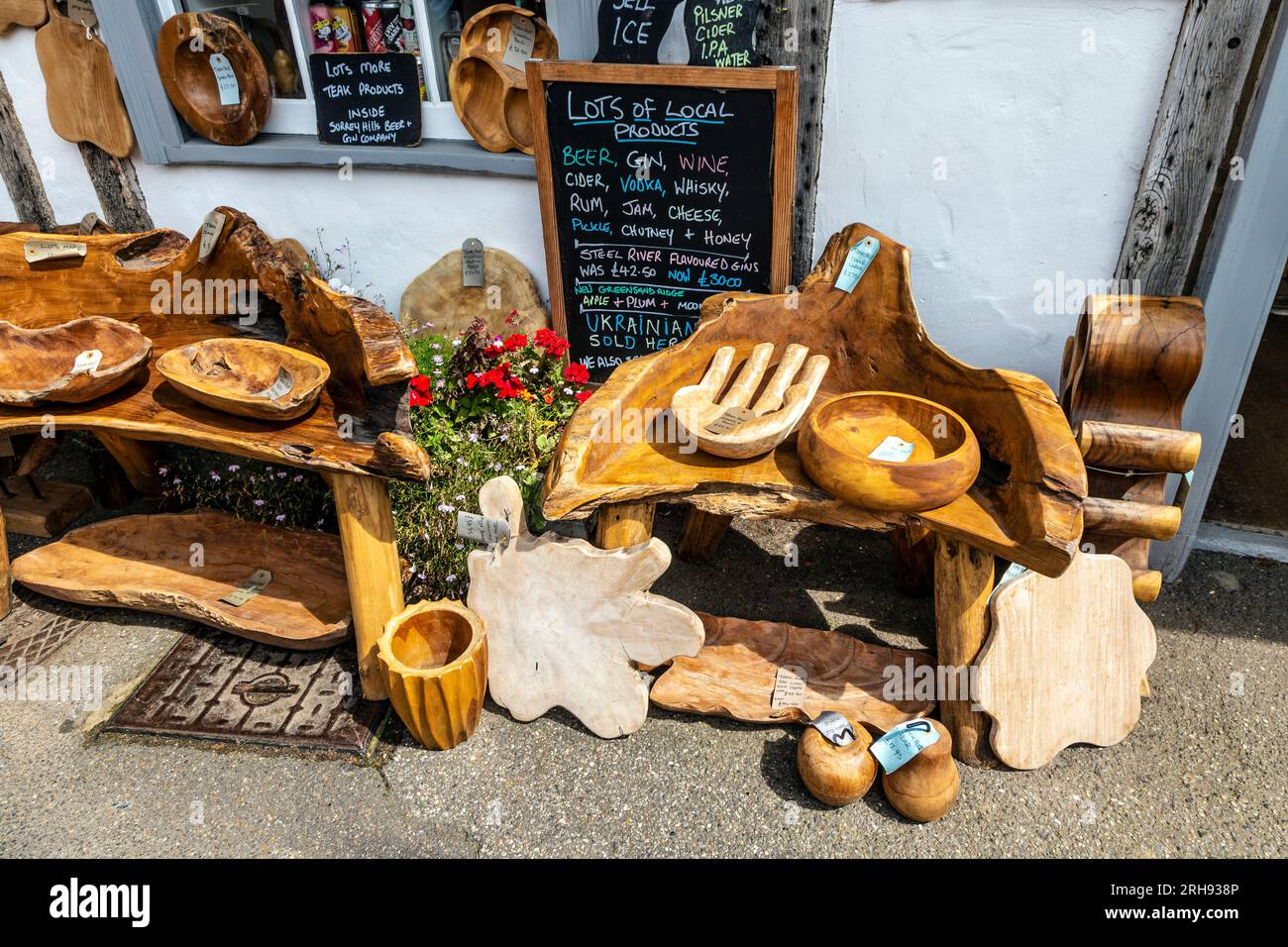 Decoración artesanal de madera rústica fuera de la tienda de cerveza y ginebra Surrey Hills, pueblo Shere, Surrey, Inglaterra Foto de stock