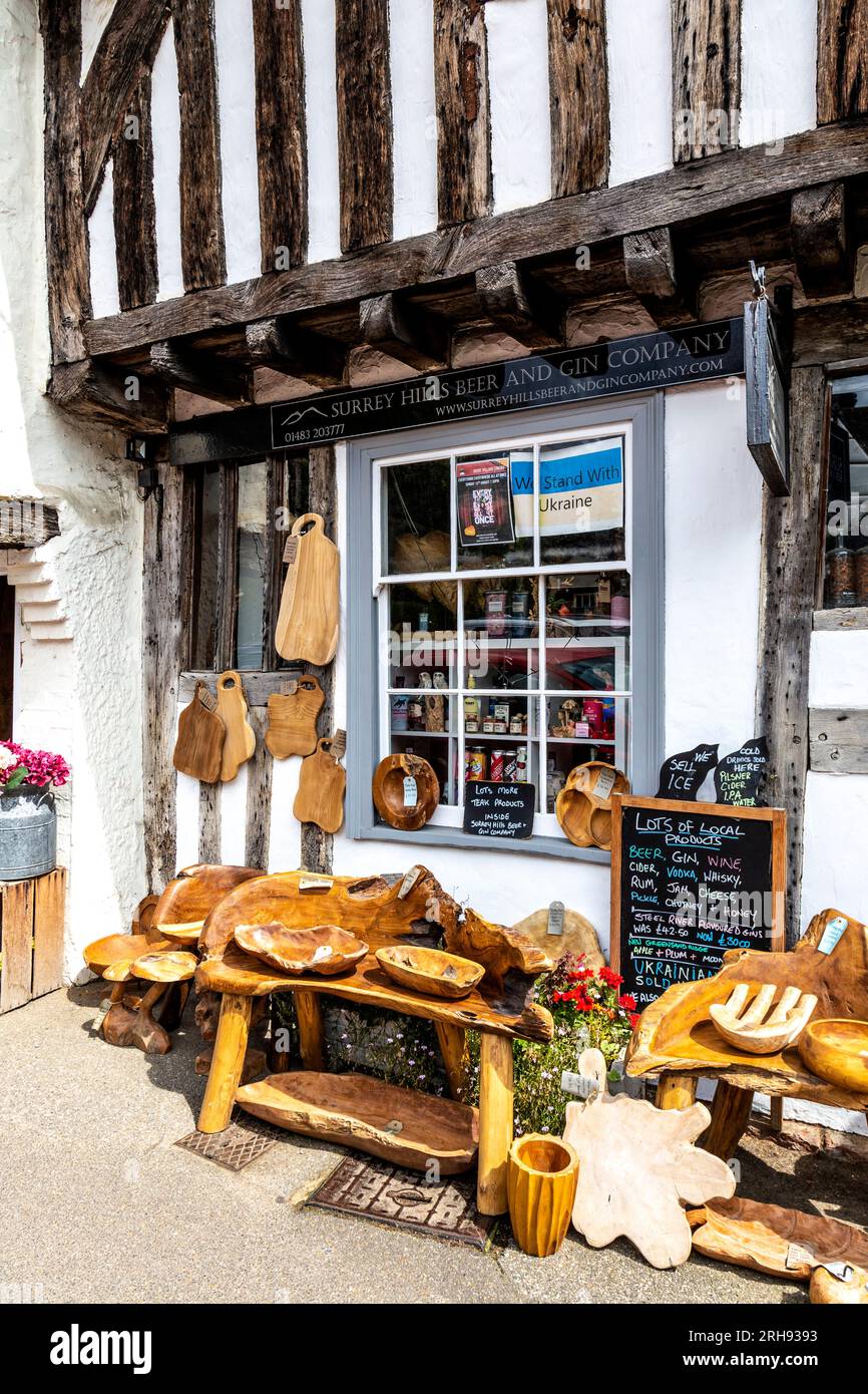 Decoración artesanal de madera rústica fuera de la tienda de cerveza y ginebra Surrey Hills, pueblo Shere, Surrey, Inglaterra Foto de stock