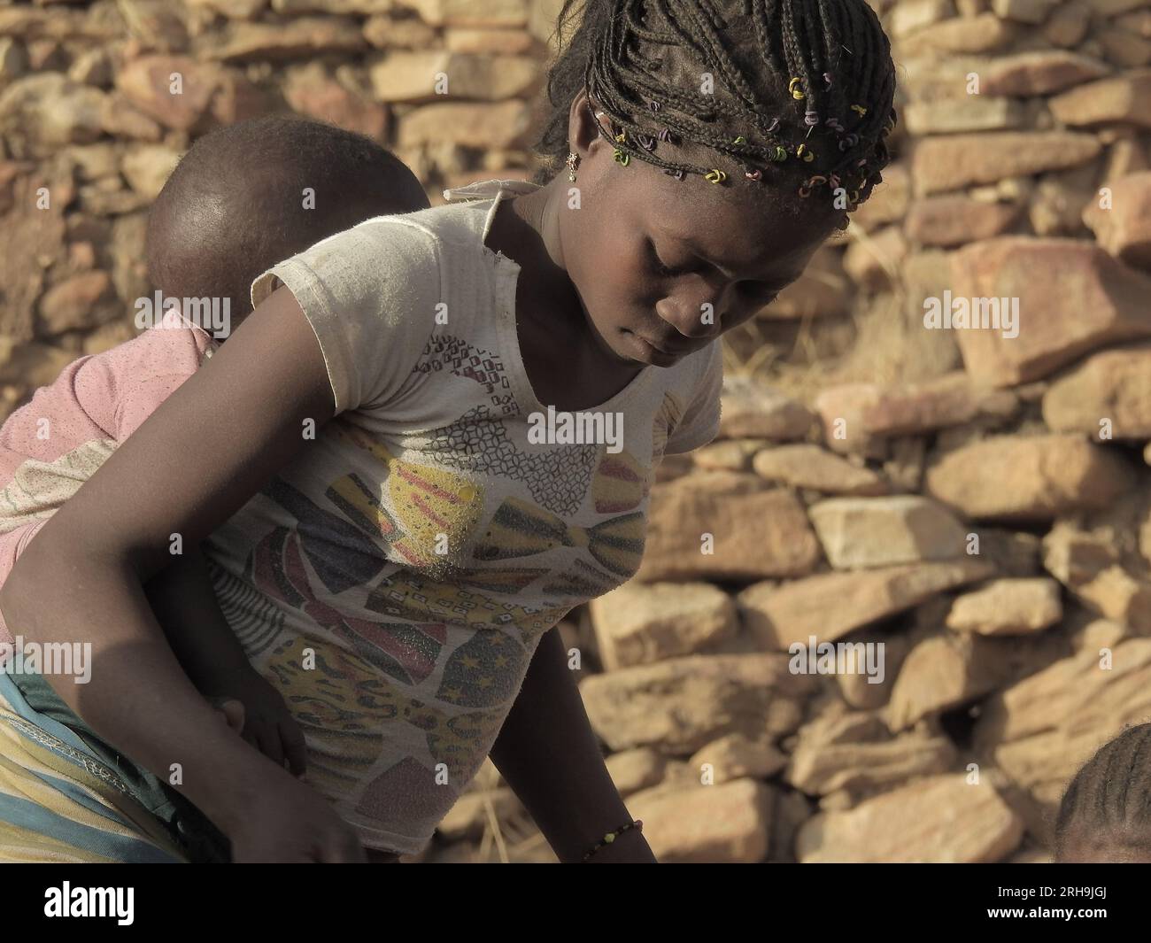 Mamá africana llevando a su hijo sobre su espalda. Mostrando la hermosa maternidad de los africanos. madres que llevan a sus hijos. Foto de stock