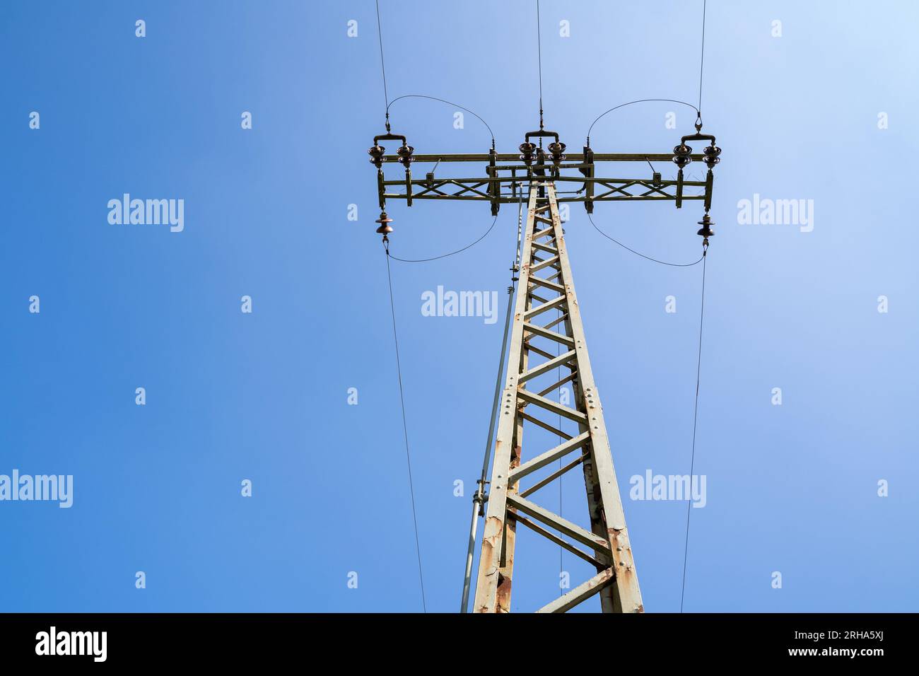 Pilón de electricidad con líneas de alta tensión en el cielo azul Foto de stock