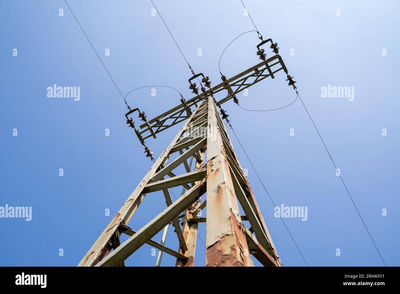 Pilón de electricidad con líneas de alta tensión en el cielo azul Foto de stock