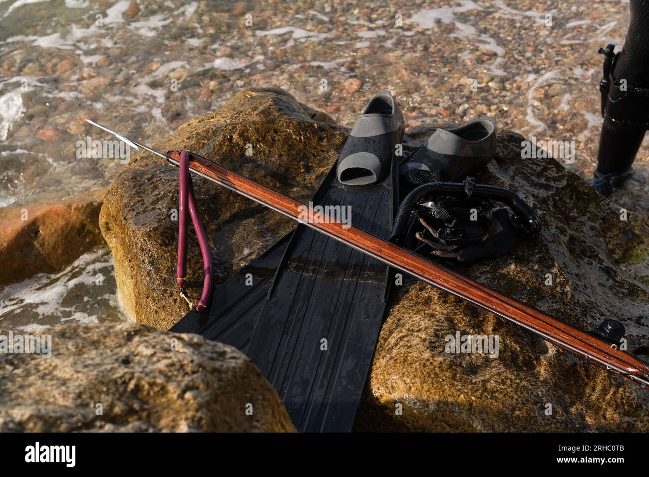 Alto ángulo de pistola de arpón para pesca submarina colocado en la roca  con aletas y equipo de buceo en la playa Fotografía de stock - Alamy