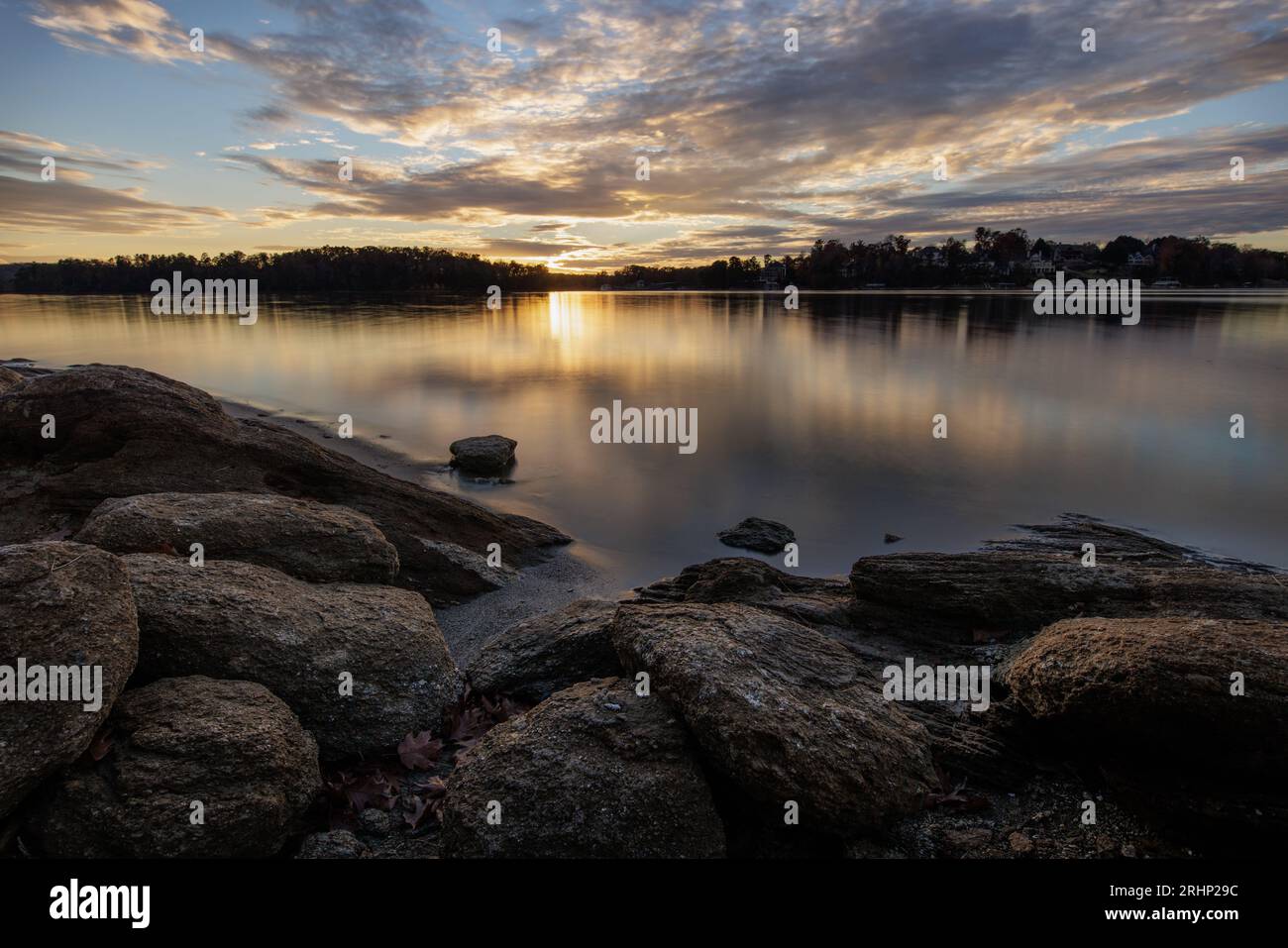 Una puesta de sol de principios de noviembre se refleja en la superficie del lago Lanier en Holly Park. Foto de stock