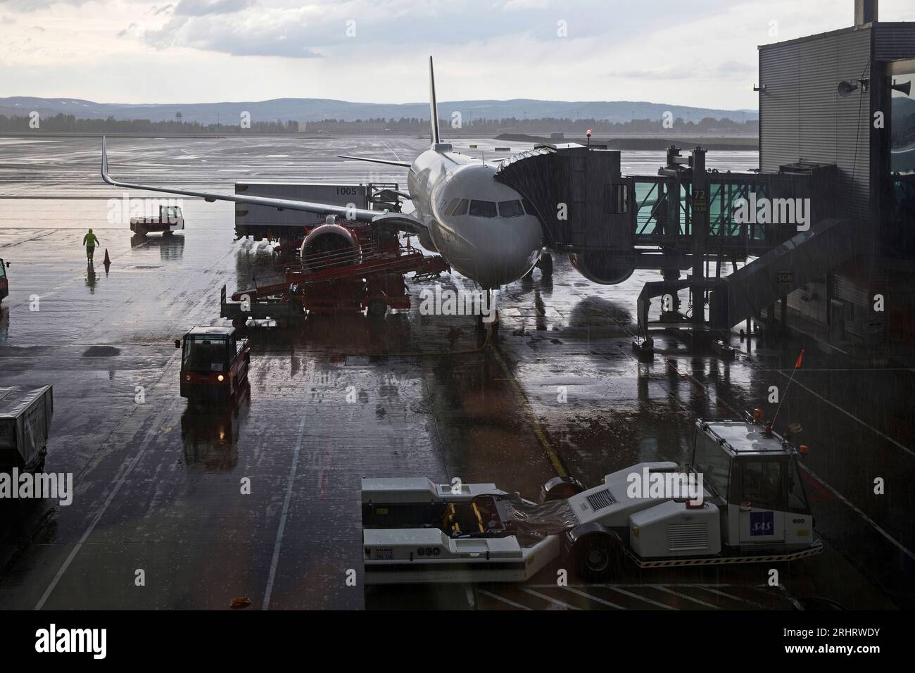 Condiciones difíciles debido a las fuertes lluvias en el aeropuerto al cargar un avión, Noruega, Oslo Foto de stock