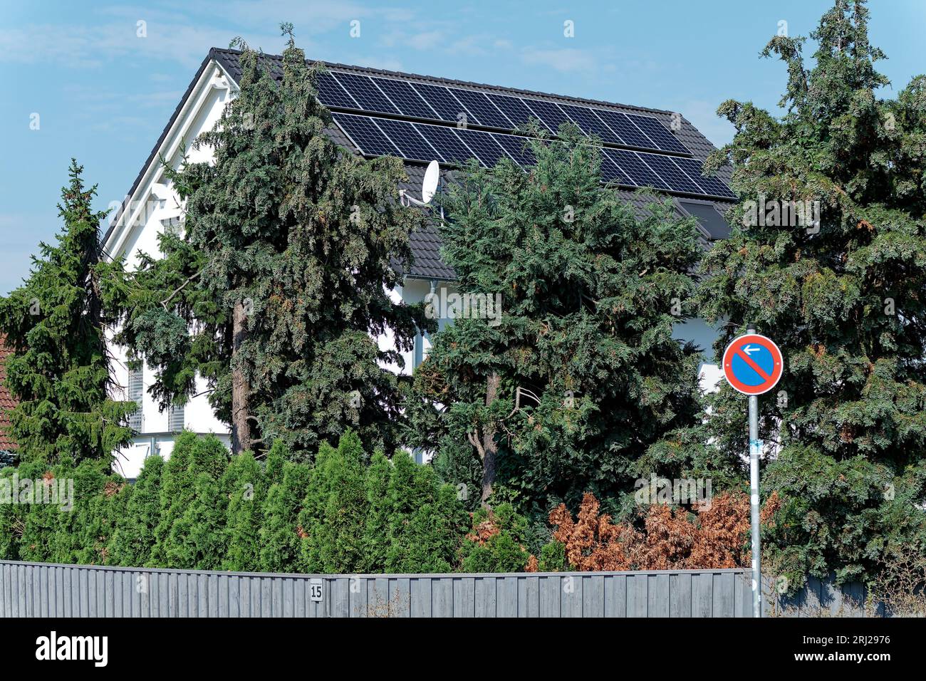 Aumento de los costos de electricidad y autoproducción de electricidad, techo de la casa con elementos fotovoltaicos Foto de stock