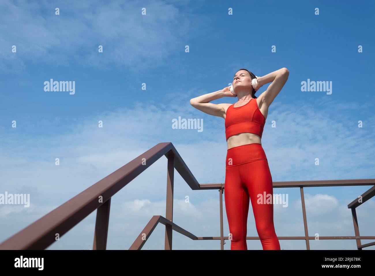 mujer deportiva con auriculares rojos escuchando música para hacer  ejercicio en el gimnasio 16248638 Foto de stock en Vecteezy