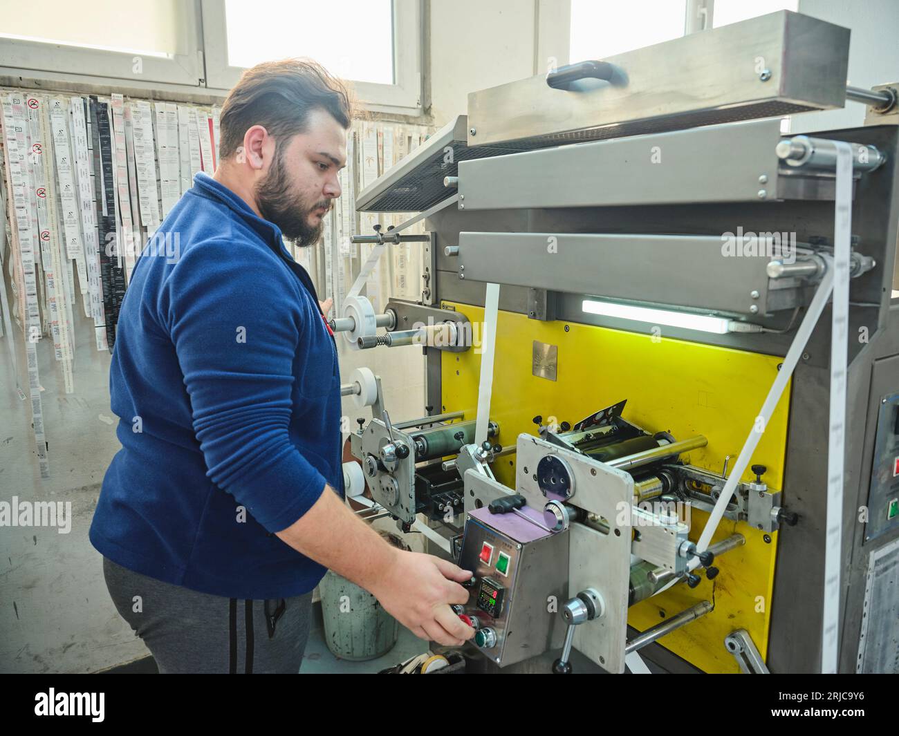 personas que trabajan en una fábrica de impresión de pegatinas. trabajador  utiliza una máquina de impresión stickier. impresora de pegatinas. máquina  de impresión trabajando en etiquetas Fotografía de stock - Alamy