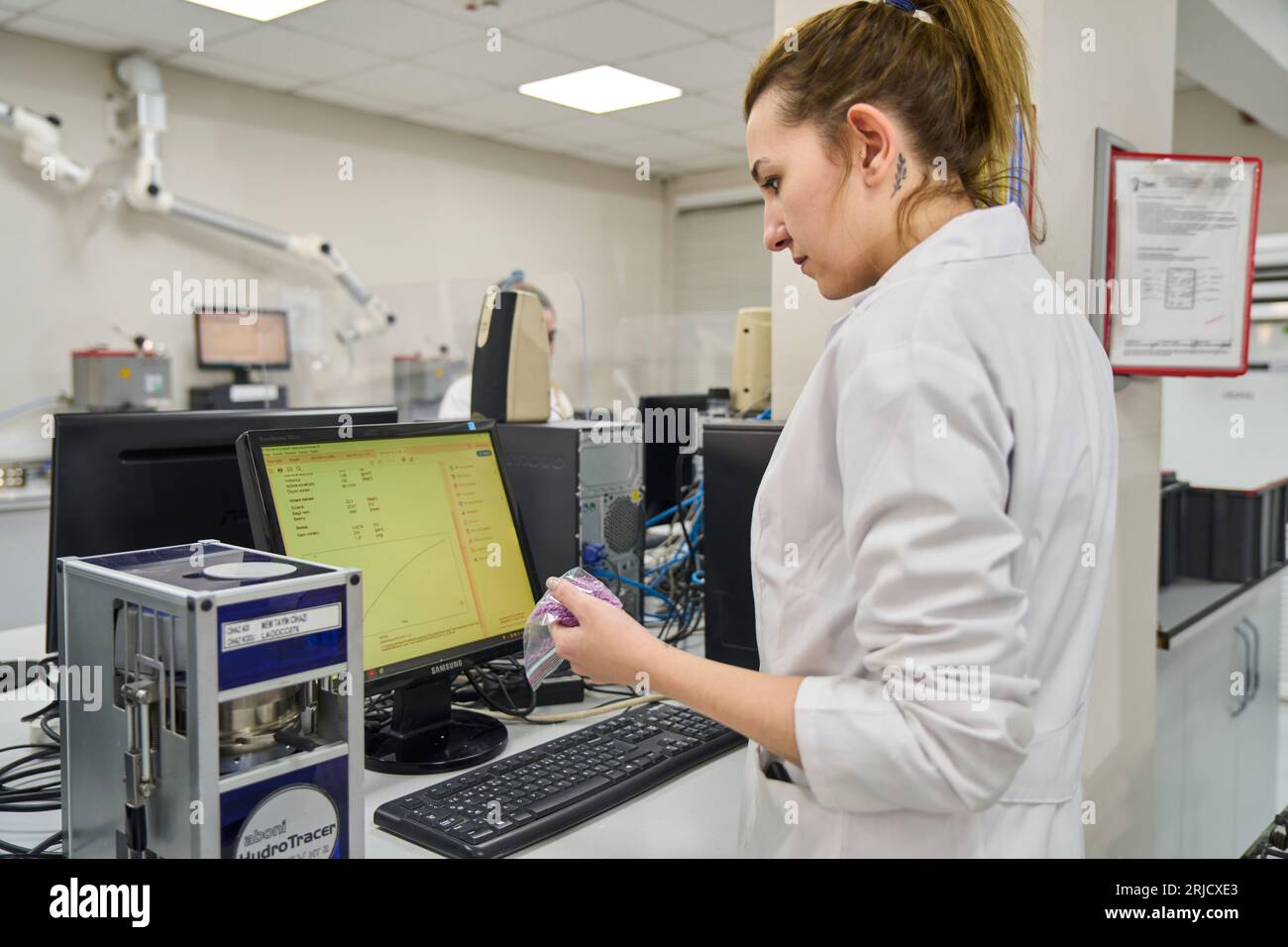 Personas que trabajan en el laboratorio de una fábrica moderna. examen de calidad del plástico que se produce en una fábrica. examen de calidad de gránulos de plástico Foto de stock