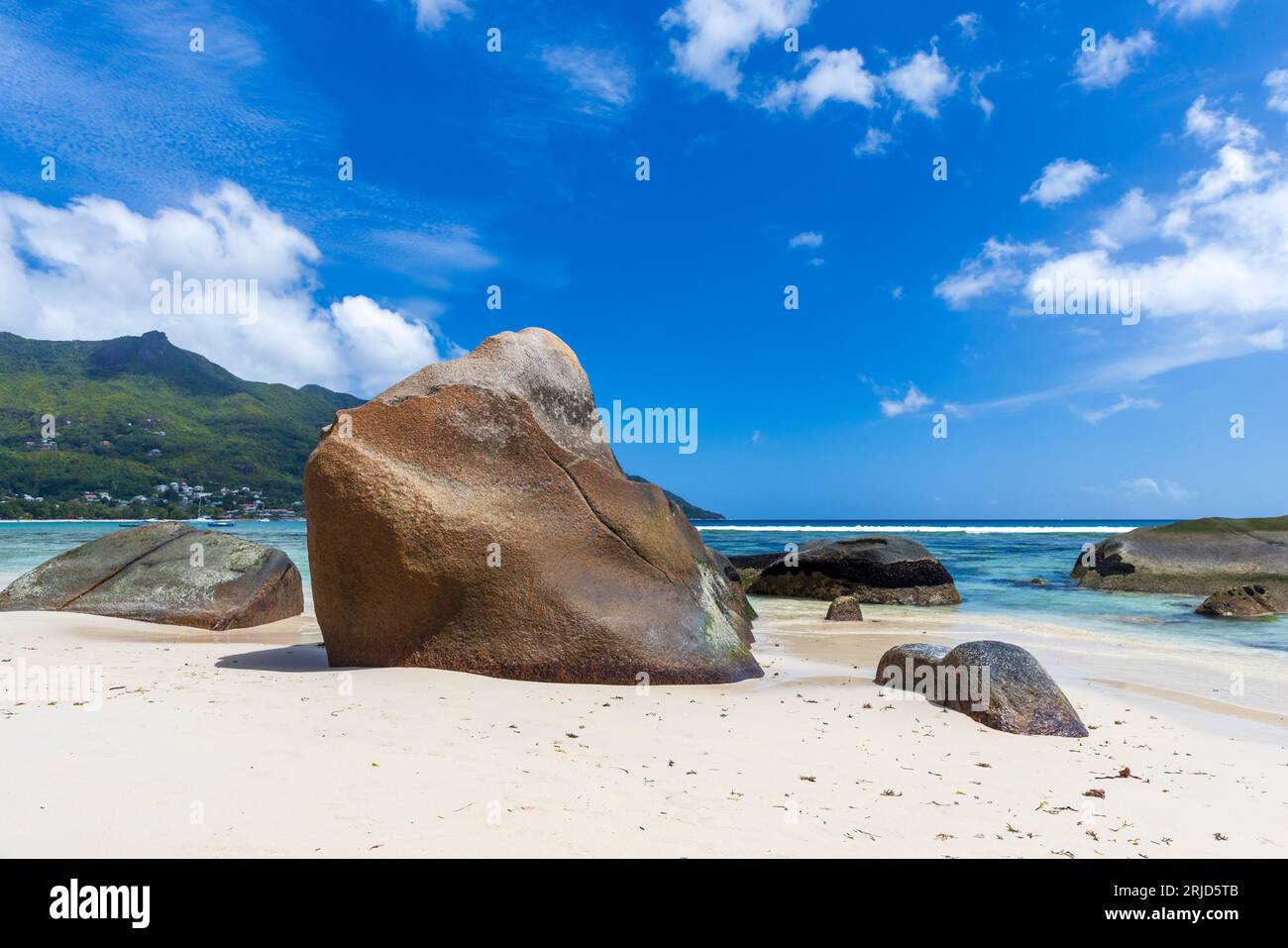 Paisaje de Beau Vallon, Seychelles. Vista a la playa con arena blanca y piedras costeras en un día soleado. Foto de stock