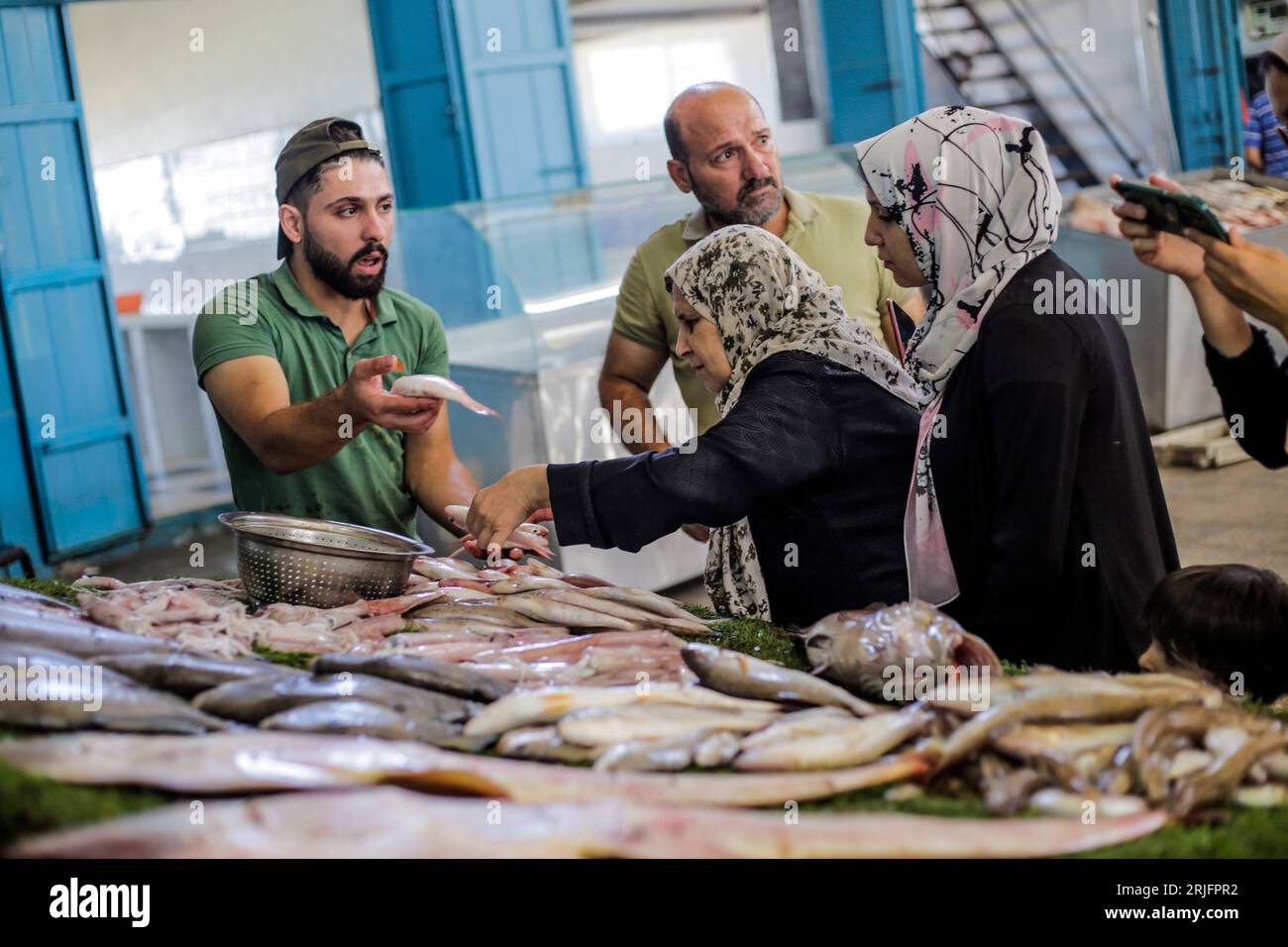 Los pescadores palestinos exhiben sus peces en el mercado central de pescado llamado 'al hesba' en la ciudad de Gaza después de regresar de un viaje de pesca desde el mar Mediterráneo, en la ciudad de Gaza. Los pescadores palestinos son objeto de violaciones diarias por parte de los barcos israelíes, y hoy ha sido una posición en solidaridad con los pescadores en el puerto de Gaza. Foto de stock