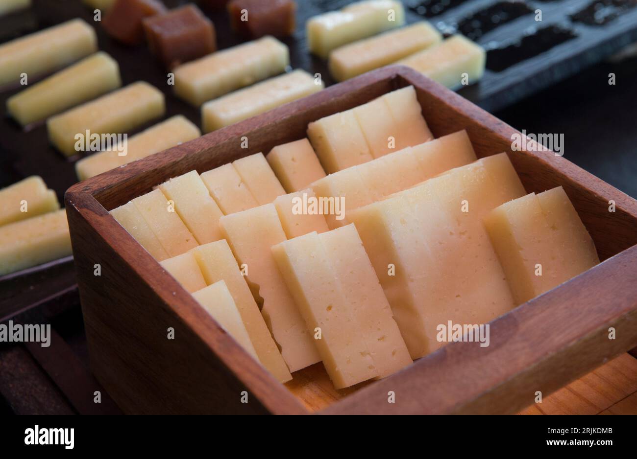 Tiras de queso de oveja exhibidas en caja de madera. Primer plano. Foto de stock
