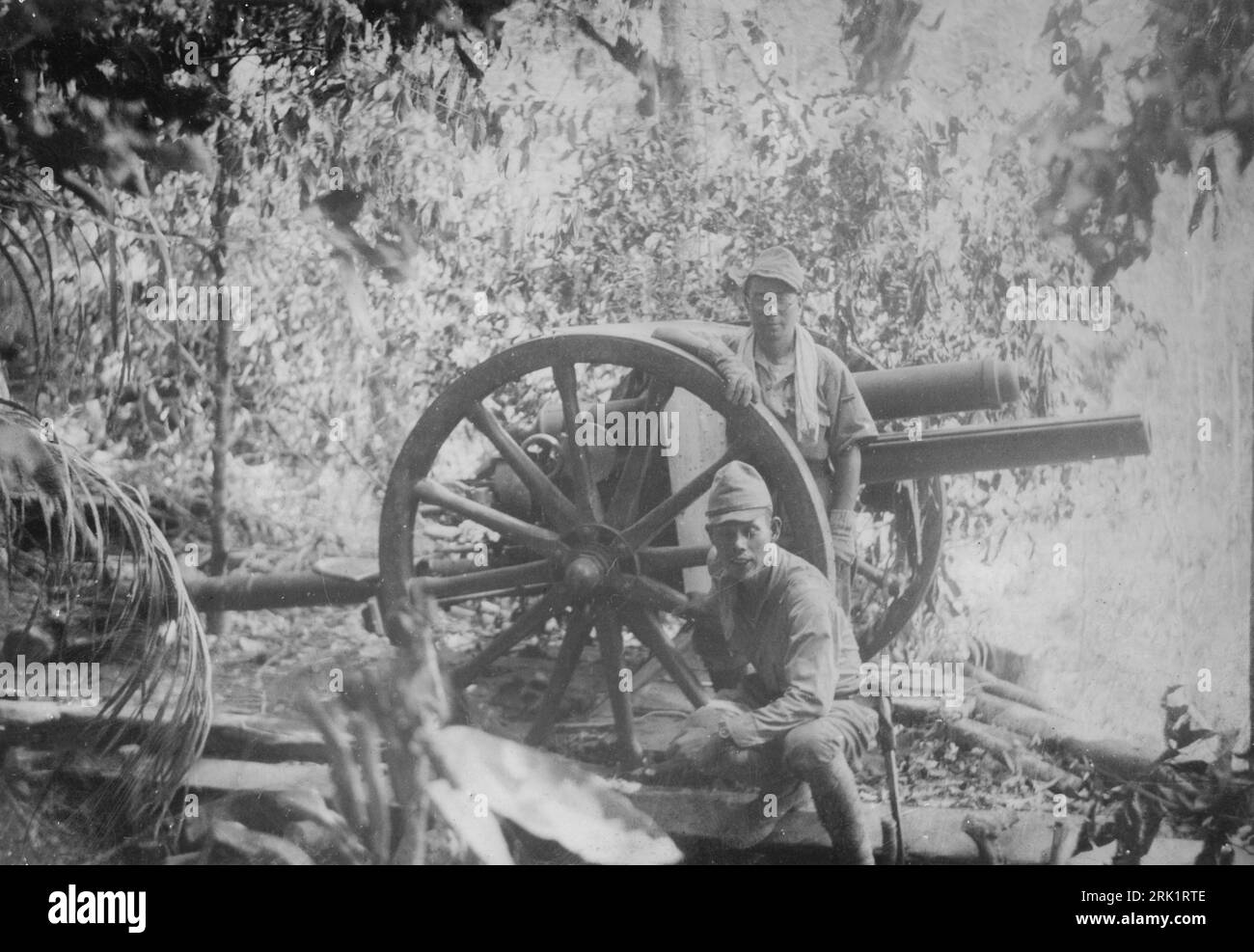 Invasión de Filipinas, diciembre de 1941 – mayo de 1942. Las tropas del Ejército Imperial Japonés posan con un cañón de campo estadounidense M1917 75mm capturado después de tomar una posición de artillería estadounidense en el Monte Samat durante la Batalla de Bataan, abril de 5 1942. Foto de stock