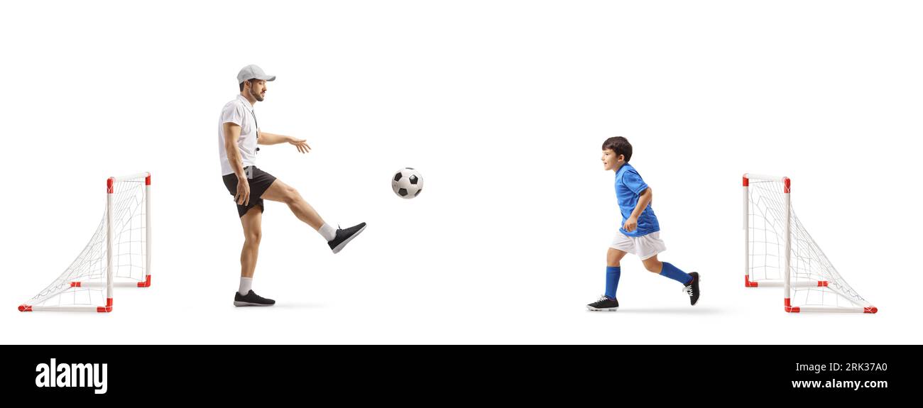 Entrenador pateando el fútbol con un niño aislado sobre fondo blanco Foto de stock