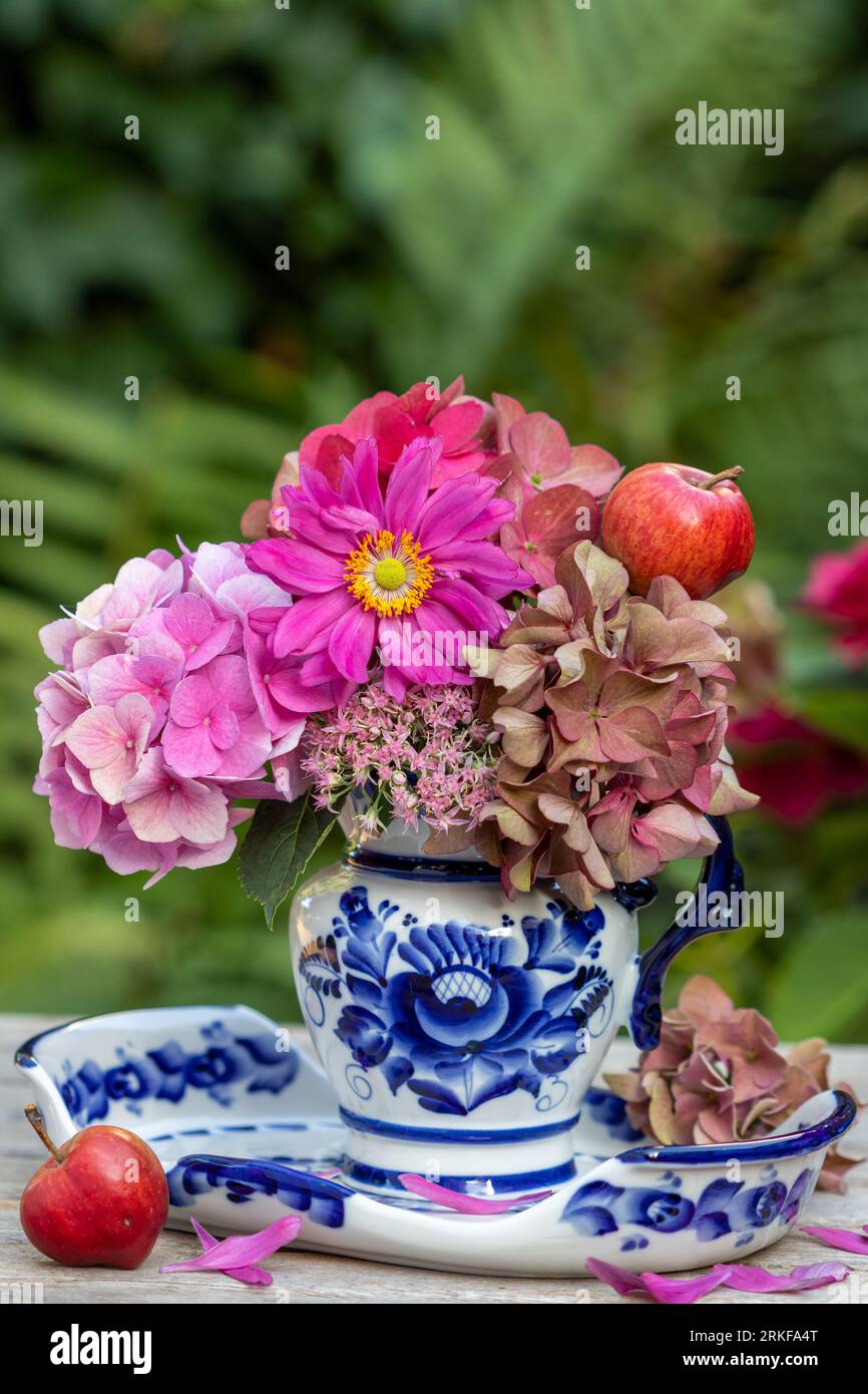 ramo de anémona japonesa rosa y flores de hortensia en lata de leche rústica Foto de stock