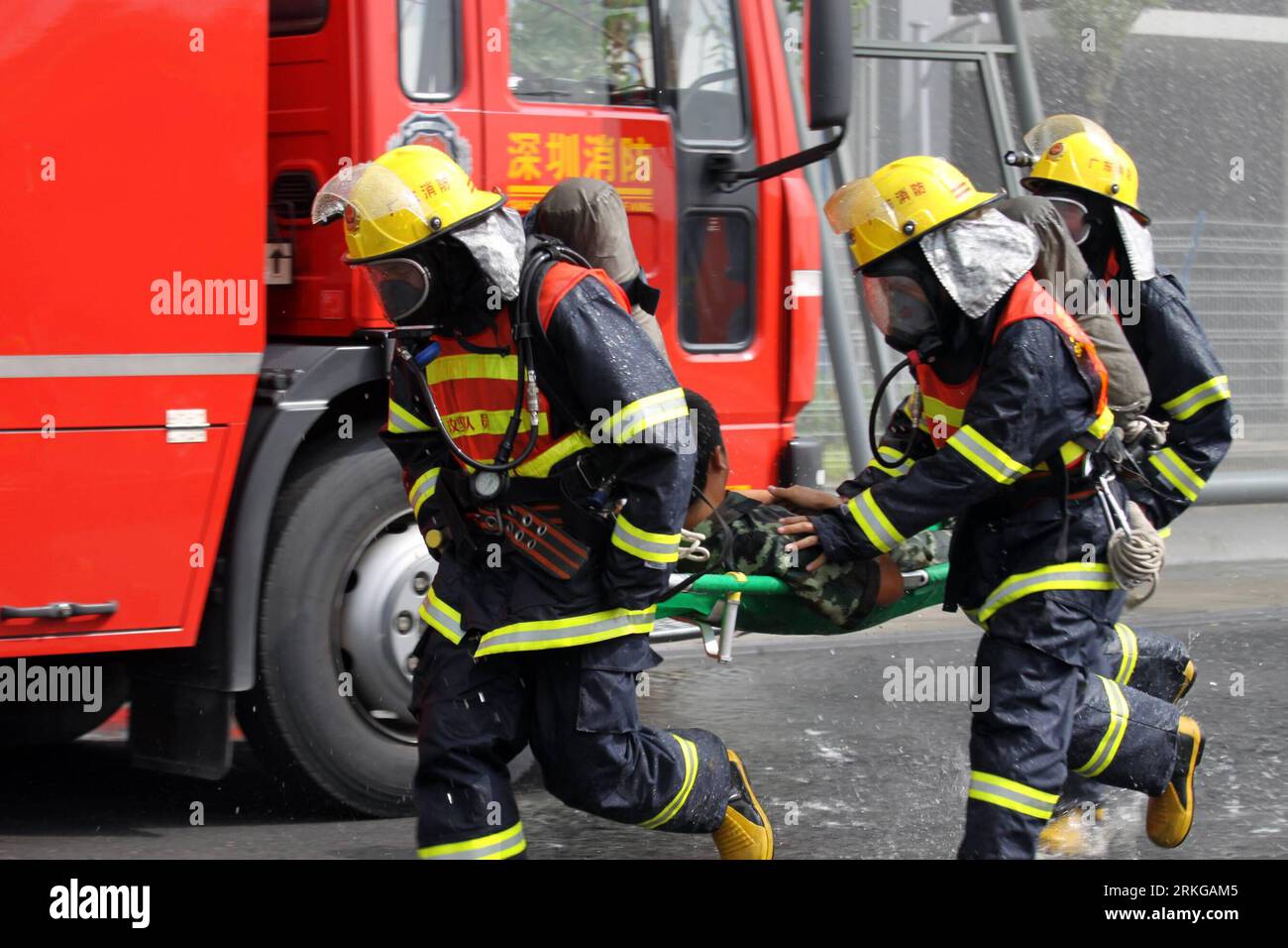 Bildnummer: 55572076 Datum: 05.07.2011 Copyright: Imago/XINHUA (110705) -- SHENZHEN, 5 de julio de 2011 (Xinhua) -- Los bomberos empujan a una persona herida en una camilla para recibir tratamiento durante un simulacro antiterrorista en Shenzhen, provincia de Guangdong, al sur de China, el 5 de julio de 2011. La autoridad de lucha contra incendios de Shenzhen realizó un simulacro antiterrorista en la aldea de atletas de la 2011 Universiade en Shenzhen el martes para probar la preparación de las fuerzas de respuesta rápida de la ciudad en caso de emergencia durante el evento deportivo de 12 días que está programado para el 12 de agosto de 2011. (Xinhua/Lu Yong) (ljh) CHINA-GUANGDONG-SHENZHEN-UNIVERSIA Foto de stock