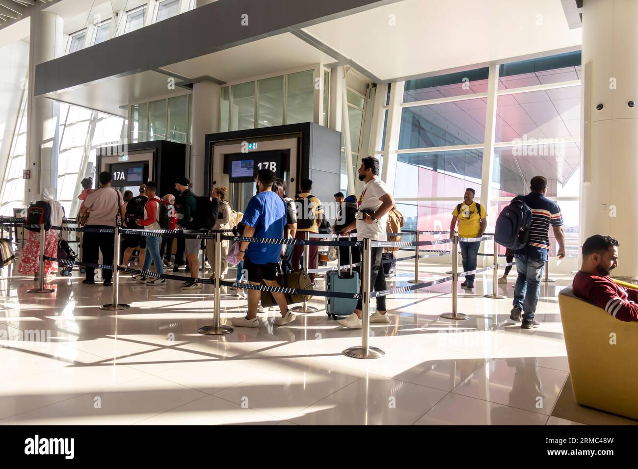 Pasajeros en las puertas antes de salir en la terminal del aeropuerto de Bahréin Foto de stock