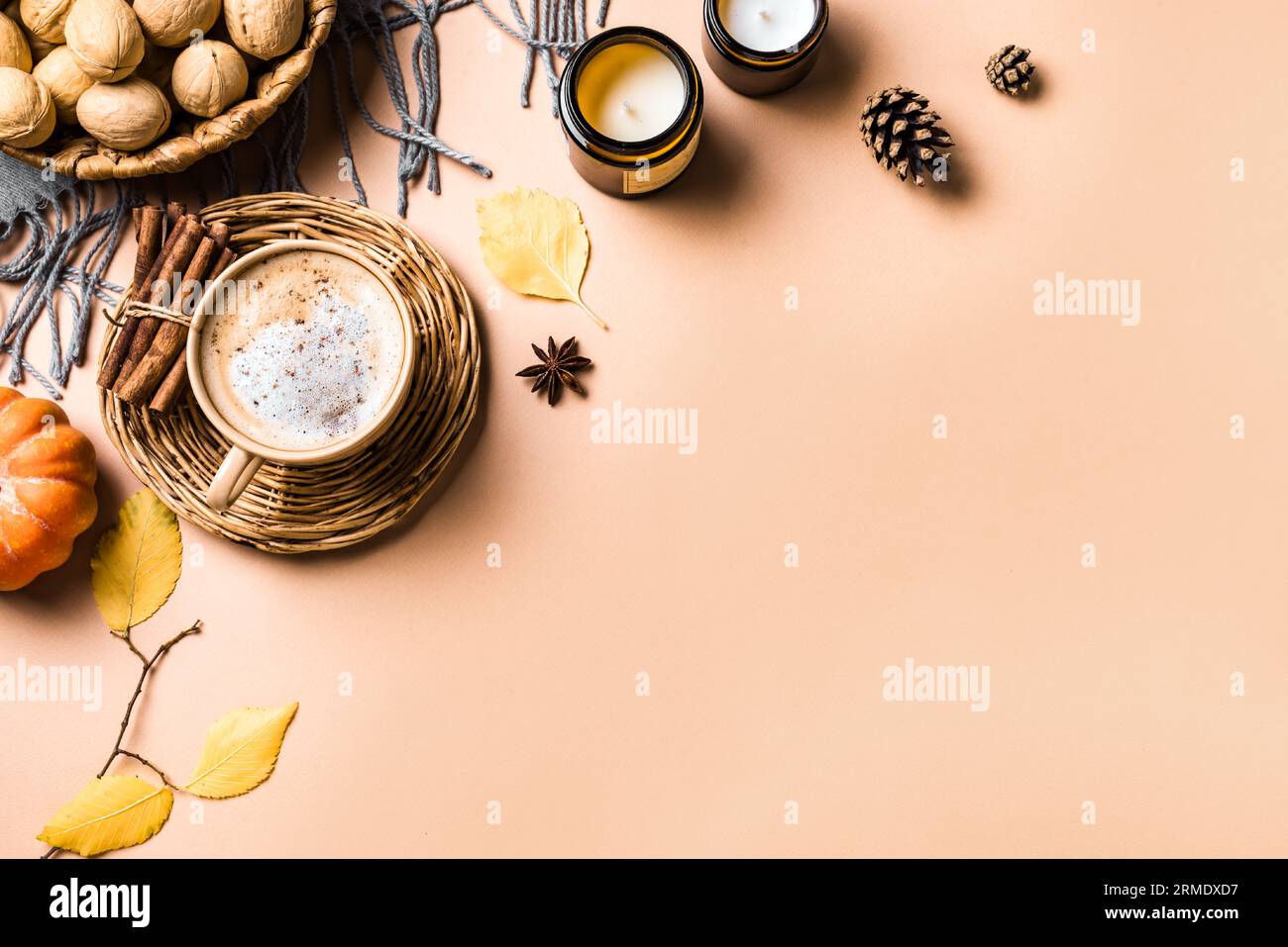 Concepto estético de otoño. Taza de café con leche de especias de calabaza, velas, calabaza y hojas amarillas de otoño sobre fondo beige, espacio de copia. Foto de stock