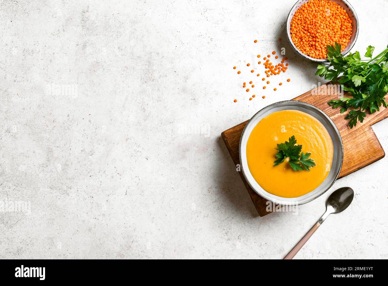 Sopa de lentejas rojas sobre fondo blanco, espacio de copia. Cocina tradicional de Oriente Medio, turca y ramadán. Comida vegana. Foto de stock