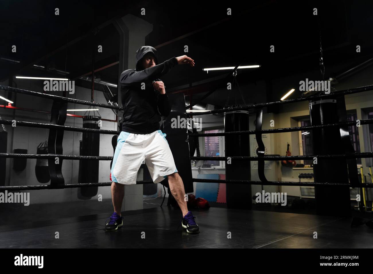 Largo tiro hombre ropa deportiva entrenamiento anillo de boxeo Fotografía  de stock - Alamy
