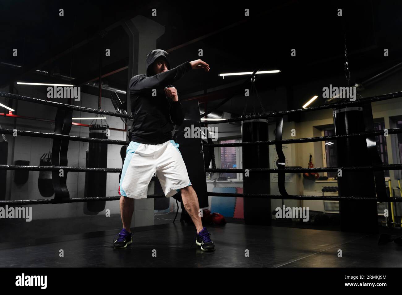 Guapo deportista muscular en ropa deportiva formación en cuadrilátero de  boxeo. Hombre Fuerte de hacer boxeo de sombra sobre rojo cuadrilátero de  boxeo en el gimnasio Fotografía de stock - Alamy