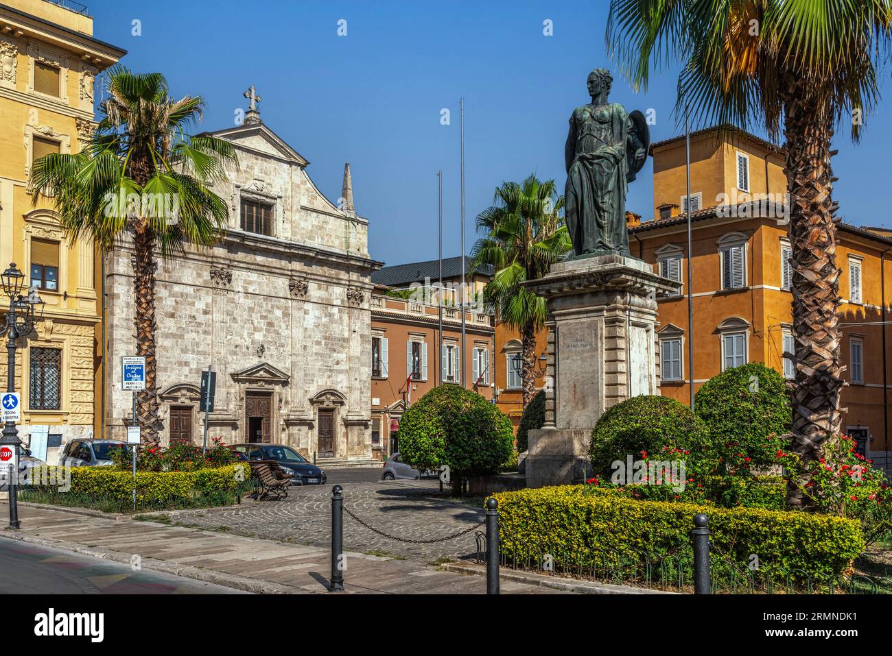 En el centro histórico de Ascoli, piazza Roma con la iglesia de Santa Maria della Carità y la estatua conmemorativa de los caídos de la gran guerra Foto de stock